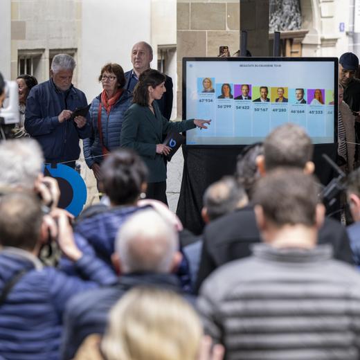 Un ecran affiche les premiers resulltat du deuxieme tour des elections, lors du second tour de l'election du Conseil d'Etat genevois, ce dimanche 30 avril 2023 a l'Hotel de Ville a Geneve lieu de la presentation des resultats du deuxieme tour de l'election du Conseil d'Etat genevois. (KEYSTONE/Martial Trezzini)