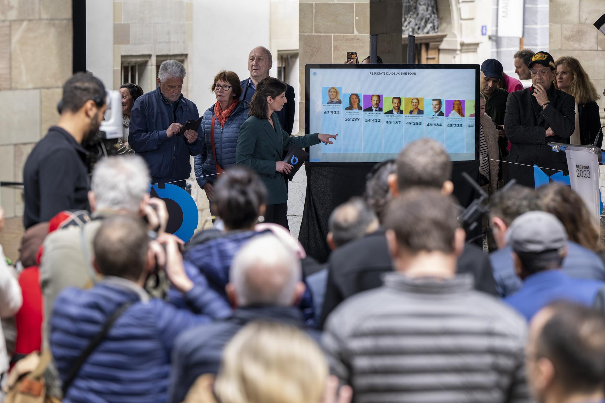 Un ecran affiche les premiers resulltat du deuxieme tour des elections, lors du second tour de l'election du Conseil d'Etat genevois, ce dimanche 30 avril 2023 a l'Hotel de Ville a Geneve lieu de la presentation des resultats du deuxieme tour de l'election du Conseil d'Etat genevois. (KEYSTONE/Martial Trezzini)