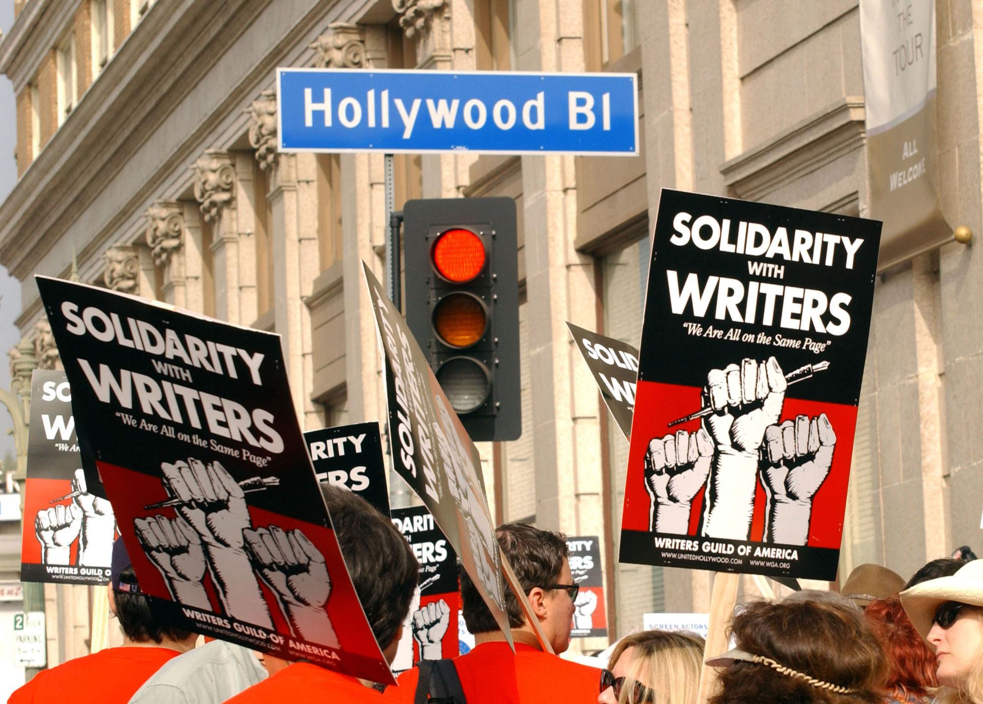 This November 20, 2007 photo shows demonstrators holding signs during the 2007–2008 Writers Guild of America strike in Hollywood. - Hollywood faced a cliffhanger moment Monday, May 1, 2023 as talks to avert a potentially catastrophic strike by thousands of TV and movie writers remained unresolved just hours before a crunch deadline.  Major studios and networks including Disney and Netflix are locked in talks with the powerful Writers Guild of America (WGA), which has threatened to order a walkout just after midnight Tuesday unless a new deal is agreed. (Photo by Chris Delmas / AFP)