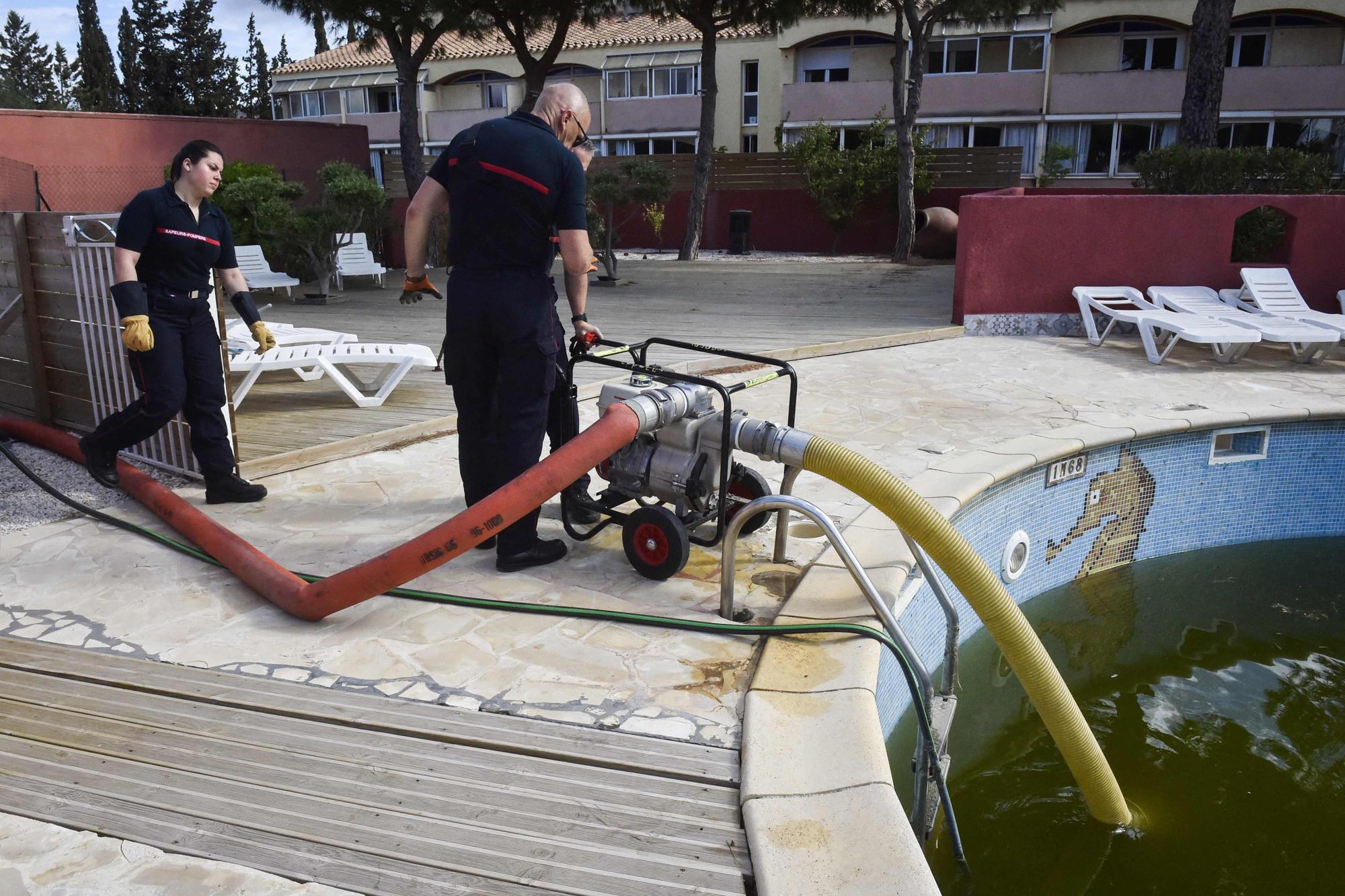 Des pompiers récoltant l'eau d'une piscine le 4 mai dans les Pyrénées-Orientales.