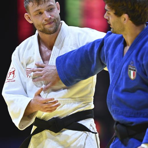 epa10617859 Nils Stump (white) of Switzerland embraces Manuel Lombardo (blue) of Italy after winning the gold medal match for the men's -73kg category of the World Judo Championships Doha 2023 in Doha, Qatar, 09 May 2023. EPA/NOUSHAD THEKKAYIL