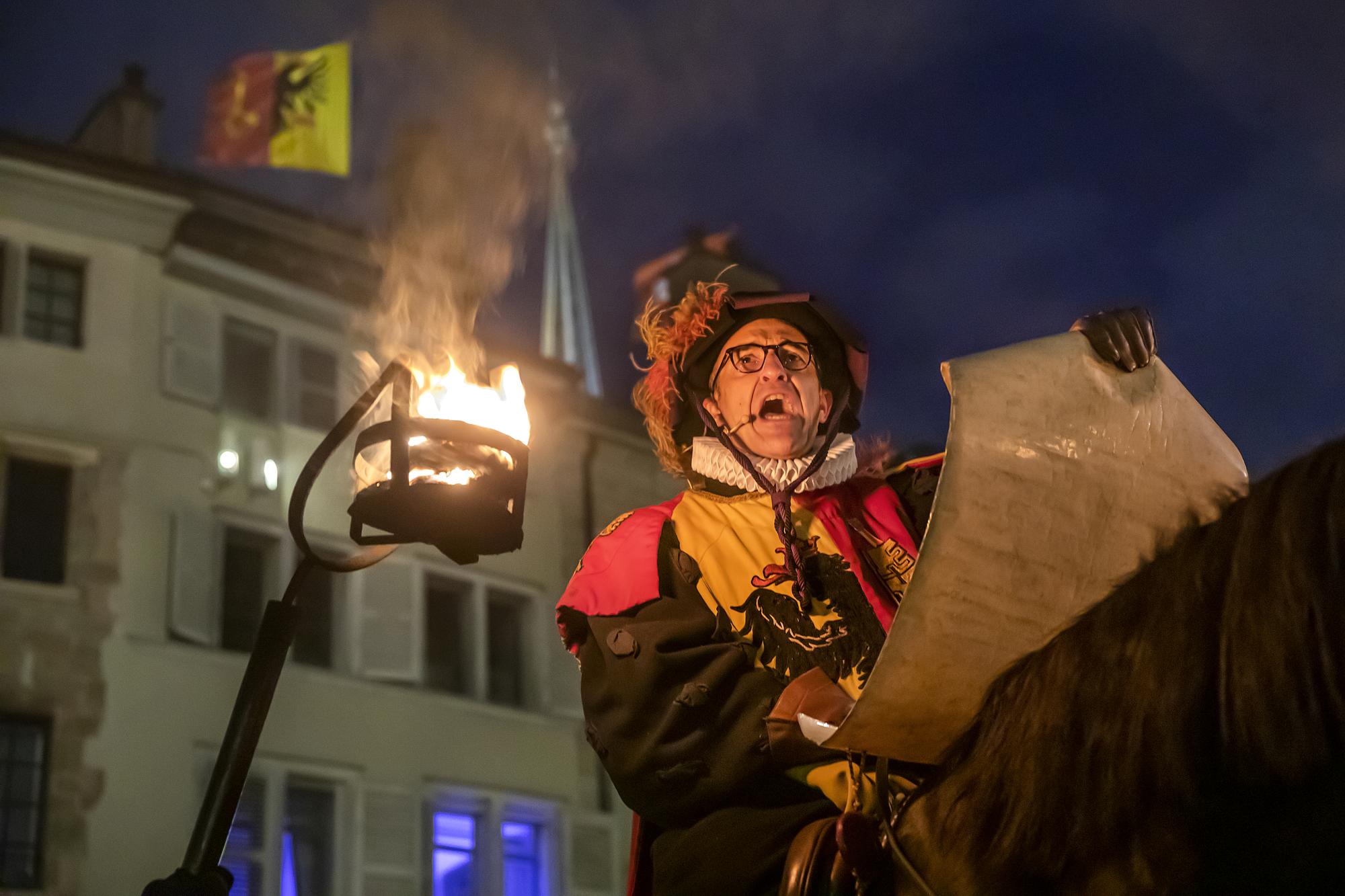 Un membre de la Compagnie 1602, lit les nouvelles lors du défilé dans la Vieille Ville de Genève pendant la commémoration de la Fête de l'Escalade, à Genève, le 11 décembre 2022.