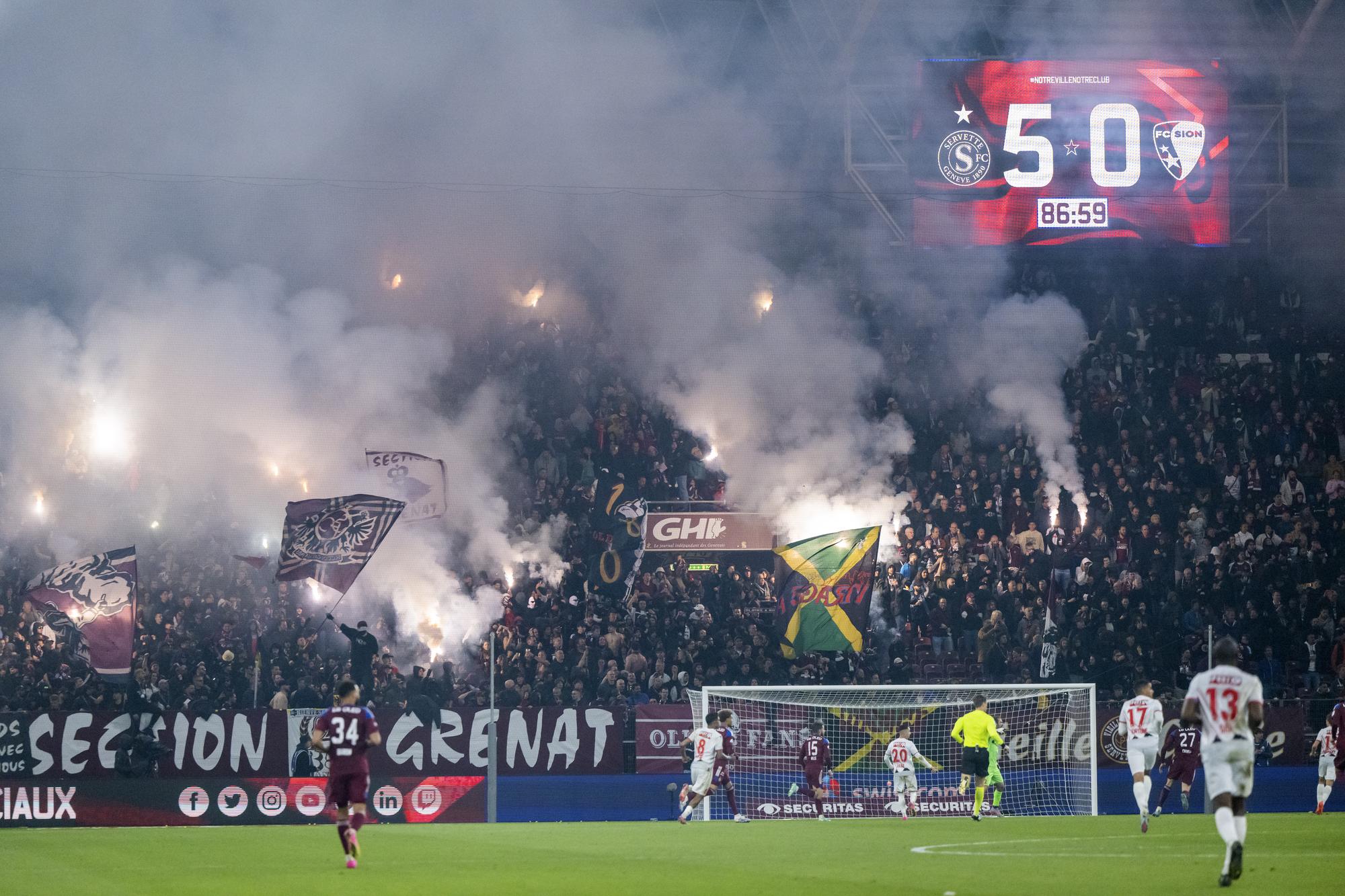 Les supportersde la section grenat allument des fumigenes pour feter leurs 35 ans et la victoire 5:0, lors de la rencontre de football de Super League entre le Servette FC et le FC Sion le samedi 13 mai 2023 au stade de Geneve. (KEYSTONE/Martial Trezzini)