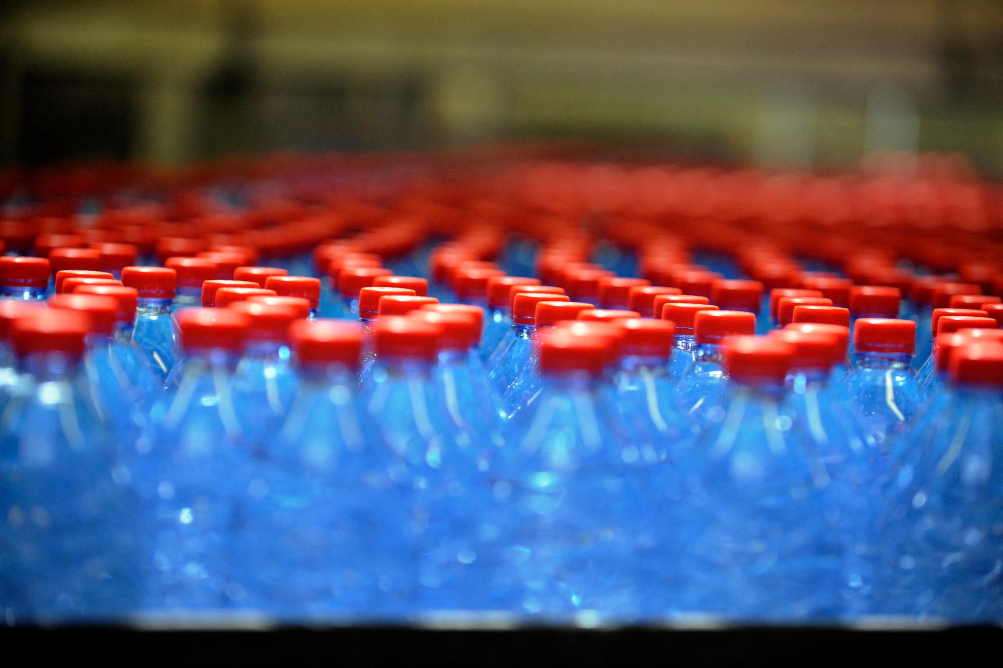 (FILES) Bottles are seen on a production line of the mineral water bottling plant of Nestle Waters Supply in Vittel, north-eastern France on July 19, 2010. Nestle Waters announced on May 16, 2023, the elimination "by the end of the year" of 171 jobs at its Vosges site, a quarter of the 721 jobs, a measure mainly motivated by the decision taken in 2022 to stop selling its Vittel water in Germany. (Photo by Jean-Christophe VERHAEGEN / AFP)
