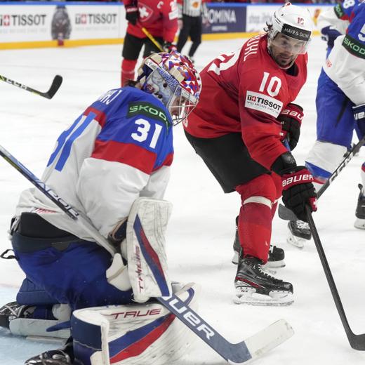 Andres Ambuhl of Switzerland, centre, fights for a puck with goalie Samuel Hlavaj of Slovakia during the group B match between Switzerland and Slovakia at the ice hockey world championship in Riga, Latvia, Thursday, May 18, 2023. (AP Photo/Roman Koksarov)