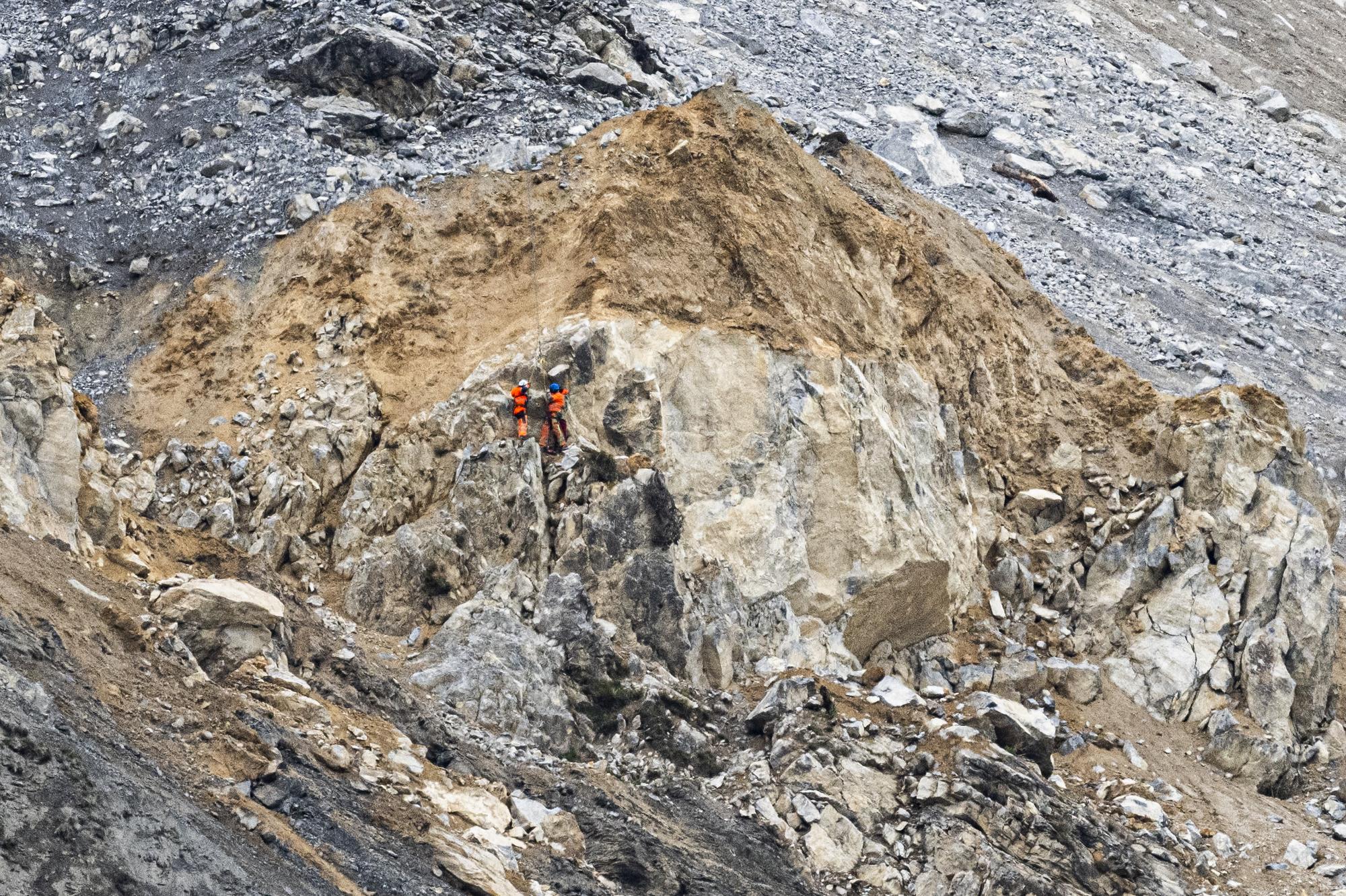 Flughelfer und Bergfuehrer an einer Longline bringen zusaetzliche Reflektorspiegel im "Brienzer Rutsch" an, am Freitag, 19. Mai 2023, in Brienz/Brinzauls. Mit den Spiegeln koennen Distanzen und Geschwindigkeiten per Laser gemessen werden. Das Dorf ist evakuiert; bis zu 2 Millionen Kubikmeter Gestein drohen abgzugehen. (KEYSTONE/Gian Ehrenzeller)