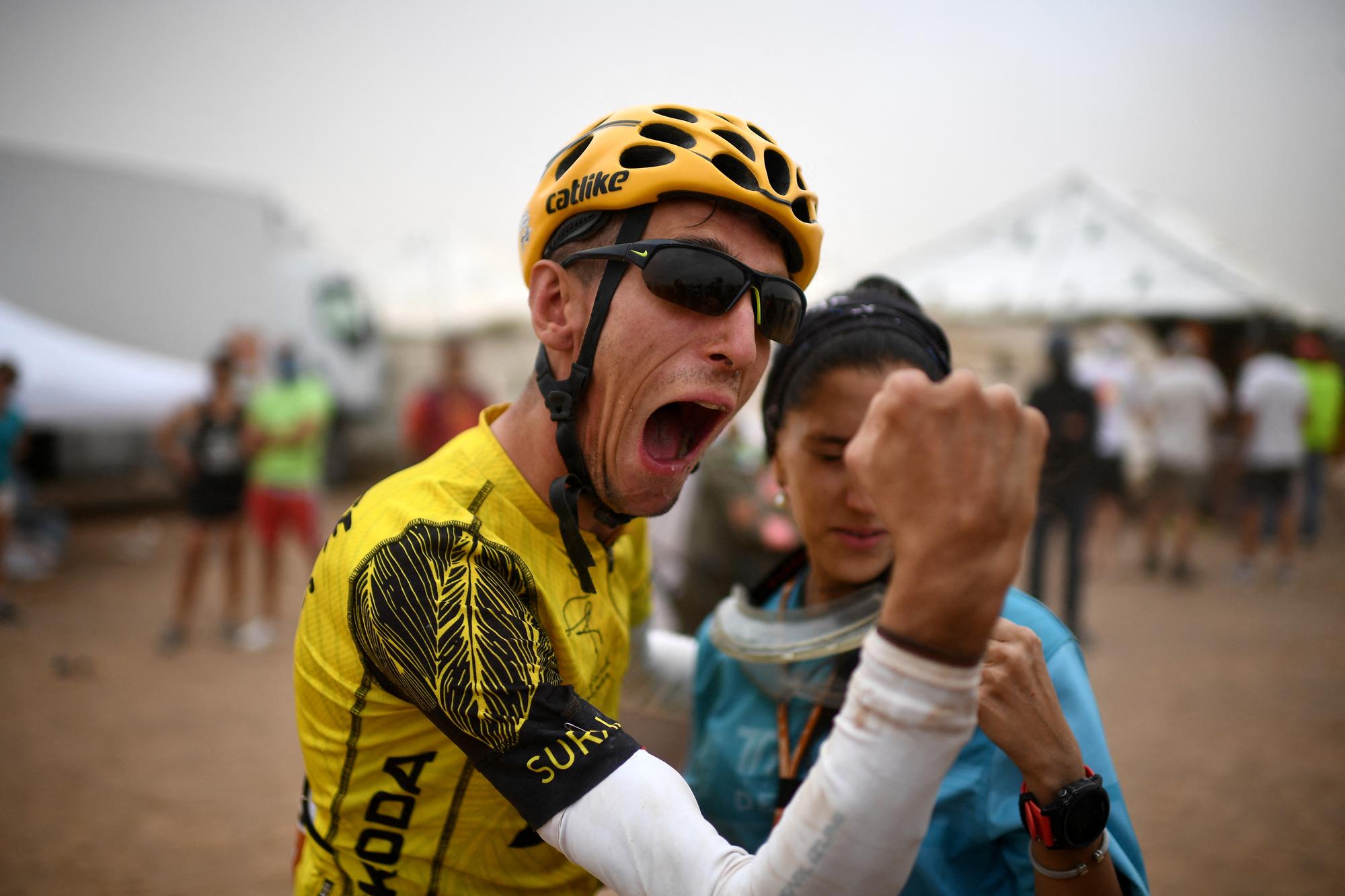 Sapin's Alex Roca Campillo celebrates with girlfriend at the end of Stage 5 of the 14th edition of Titan Desert 2019 mountain biking race between M'ssici and El Jorf, in Morocco, on May 2, 2019. Campillo is the first person living with cerebral palsy to participate in the Titan race. (Photo by FRANCK FIFE / AFP)