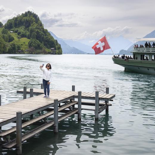 A Korean visitor takes selfie pictures at the pier in Iseltwald, Switzerland, Sunday, May 21, 2023. Lots of Asian TV fans and tourists visit the place because the romantic Korean Netflix drama 'Crash Landing On You' was filmed in the Interlaken region of Switzerland, with key scenes set on Iseltwald's picturesque pier as well as nearby Sigriswil and Lungern. The visitors have now to pay a of 5 Swiss francs to get on the pier. (KEYSTONE/Peter Klaunzer)
