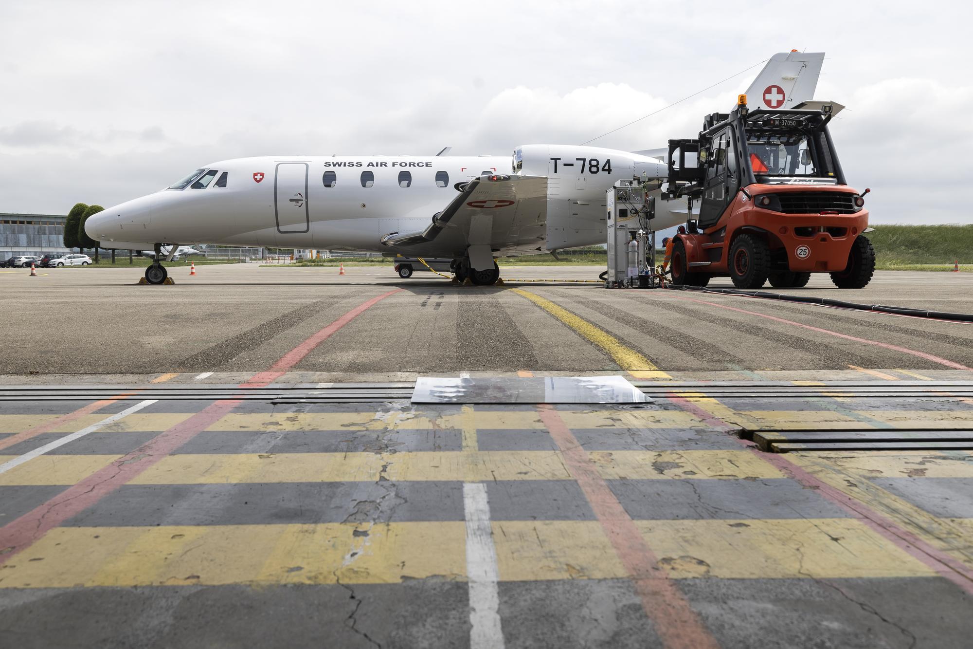 Un avion de la Swiss Air Force au sol est connecte a des machines qui analysent les emissions du moteur lors du teste d'un nouveau carburant d'aviation durable ce mercredi, 24 mai 2023 a l'aerodrome militaire de Payerne. Les Forces aeriennes suisses veulent reduire l'impact du trafic aerien militaire sur le climat. Elle teste un carburant d'aviation durable (Sustainable Aviation Fuel SAF) afin de reduire la quantite d'emissions de suies ultrafines et de dioxyde de carbone fossile (CO2). (KEYSTONE/Cyril Zingaro)