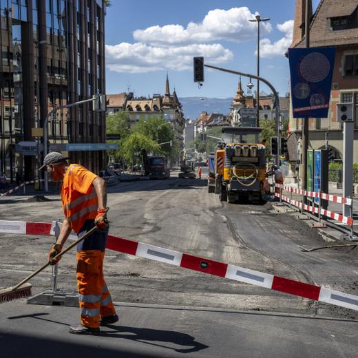 Un ouvrier balaie la route afin de pouvoir poser un nouveau revetement, un enrobe bitumineux de goudron phonoabsorbant, lors d?une conference de presse du syndicat UNIA afin de denoncer que sur les chantiers publics de genie civil, les conditions legales de protection des travailleurs ne sont pas reunies et mettent en danger leur sante, en periode de canicule. Une bonne soixantaine de chantiers a ete visitee par Unia et une trentaine de denonciations ont ete faites aupres des inspections du travail. Elles concernaient notamment l?absence de pauses regulieres, de mise a disposition d?eau et d?un lieu de pause au frais, ou encore la pratique de travaux lourds aux heures tres chaudes. (KEYSTONE/Martial Trezzini)