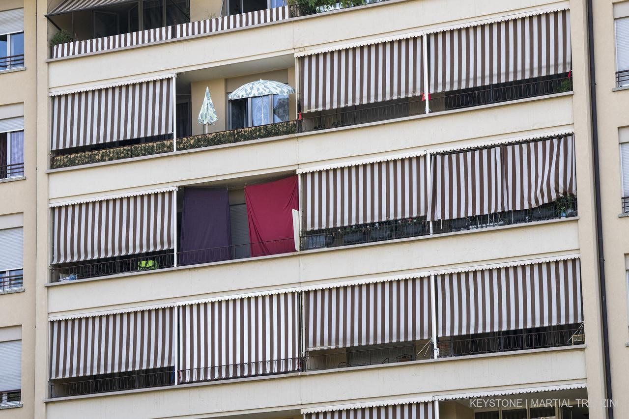 Une facade d?un immeuble est photographiee avec des parasols de jardin et les stores en toile pour balcon qui sont fermes afin d?assurer au mieux la fraicheur dans les appartements en cette periode de canicule, ce mercredi 20 juillet 2022 a Geneve. (KEYSTONE/Martial Trezzini)