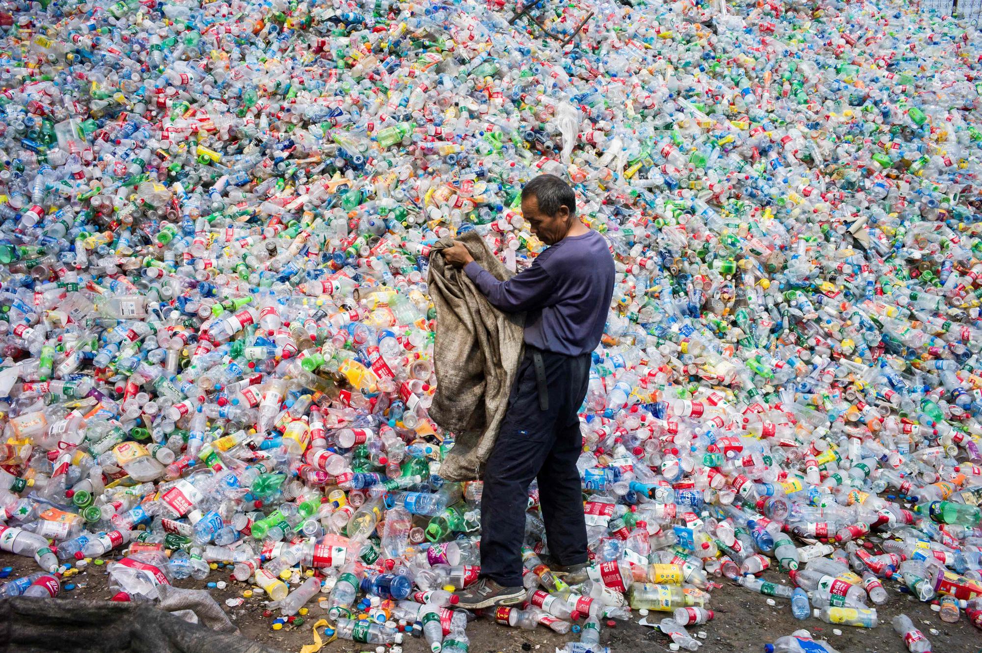 (FILES) This photo taken on September 17, 2015 shows a Chinese labourer sorting out plastic bottles for recycling in Dong Xiao Kou village, on the outskirt of Beijing. China is the world's biggest emitter of the greenhouse gases that cause climate change, and a crucial player in the global gathering finishing on December 11 in Paris, where nations have been trying to thrash out a plan to limit dangerous global warming. The 195-nation UN climate rescue talks in the French capital have been billed as the last chance to avert worst-case-scenario climate change impacts: increasingly severe drought, floods and storms, as well as island-engulfing rising seas. AFP PHOTO / FRED DUFOUR. Negotiations on a global treaty to combat plastic pollution will resume on May 29, 2023, with nations under pressure to stem the tide of trash amid calls from campaigners to limit industry influence on the talks. Some 175 nations pledged last year to agree by 2024 a binding deal to end the pollution from largely fossil fuel-based plastics that is choking the environment and infiltrating the bodies of humans and animals. The May 29-June 2 talks in Paris are tasked with agreeing the first outline for actions that could form the basis of a draft negotiating text. (Photo by Fred DUFOUR / AFP)