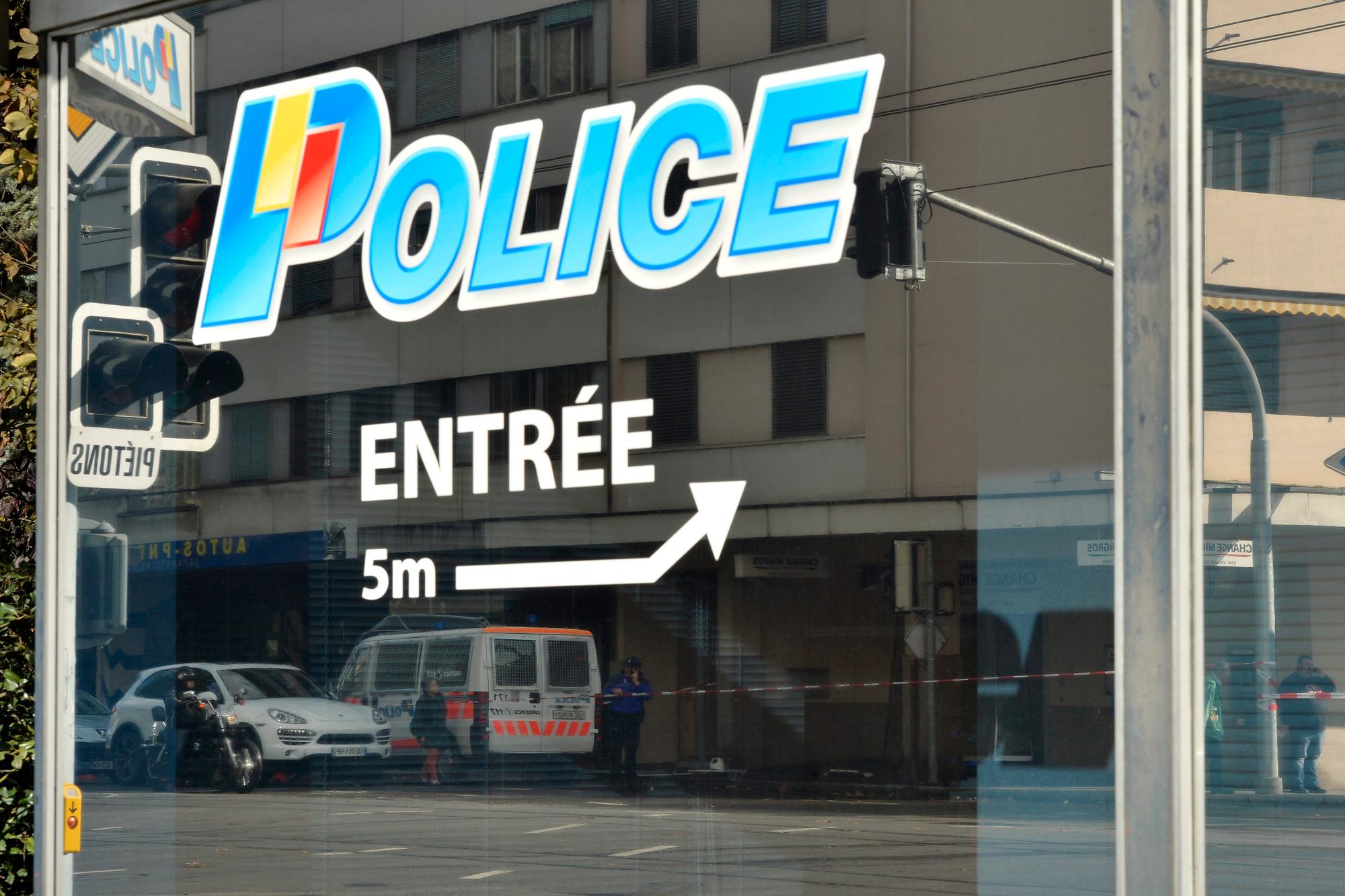Le reflet du bureau de change Migros ou a eu lieu une tentative de braquage, photographie dans la vitre du poste police qui se trouve vis-a-vis, ce samedi 2 novembre 2013 a Thonex pres de Geneve. Des inconnus s'en sont pris au bureau de change Migros de Thonex a la voiture-belier. Mais leur tentative a fait chou blanc. Ils ont alors fait feu sur des policiers qui etaient aussitot sortis de leur poste situe juste en face. Un echange de tirs s'en est suivi, sans faire apparemment de blesse. Aucun gendarme n'a ete touche. Quant aux braqueurs, ils ont pris la fuite et une operation de recherche est en cours. (KEYSTONE/Martial Trezzini)....In Thonex bei Genf ist es am Samstagmorgen, 2. November 2013, beim versuchten Einbruch in eine Bank zu einer Schiesserei mit der Polizei gekommen. Die Räuber ergriffen daraufhin die Flucht. Verletzt wurde niemand. (KEYSTONE/Martial Trezzini)