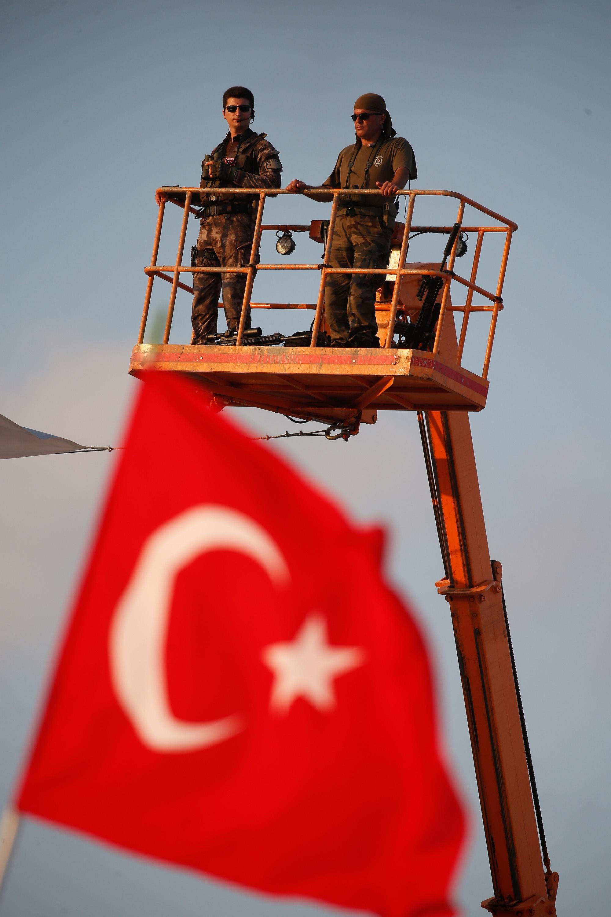 Turkish special forces unit stand on a crane during a Democracy and Martyrs' Rally in Istanbul, Sunday, Aug. 7, 2016. A massive flag-waving crowd, the size of which some Turkish media said had never been seen before, gathered in Istanbul Sunday for a giant rally to mark the end of nightly demonstrations since Turkey's July 15 abortive coup that left more than 270 people dead. (AP Photo/Emrah Gurel)