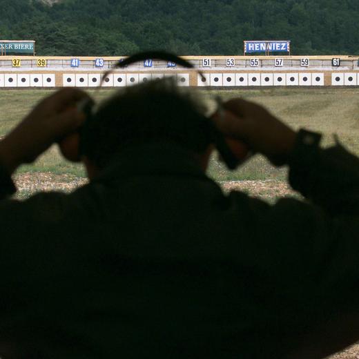 Un tireur ajuste son casque de protection acoustique avant de tirer sur l'une des 300 cibles, lors de la journee d'ouverture du Tir Federal 2000 a Biere VD, ce vendredi 23 juin 2000. Du 23 juin au 16 juillet et cinq ans apres la derniere edition de Thoune, la Place d'armes de Biere accueille le Tir Federal. Un evenement pour la Suisse romande, qui n'a pas accueilli cette manifestation depuis 1954. Quelques 56 000 tireurs rivaliserons d'adresse, durant les trois semaines que dureront la manifestation. Au total, ils tireront 3,5 millions de cartouches, soit 13 tonnes de plomb et autant d'acier. (KEYSTONE/Fabrice Coffrini) ===ELECTRONIC IMAGE===