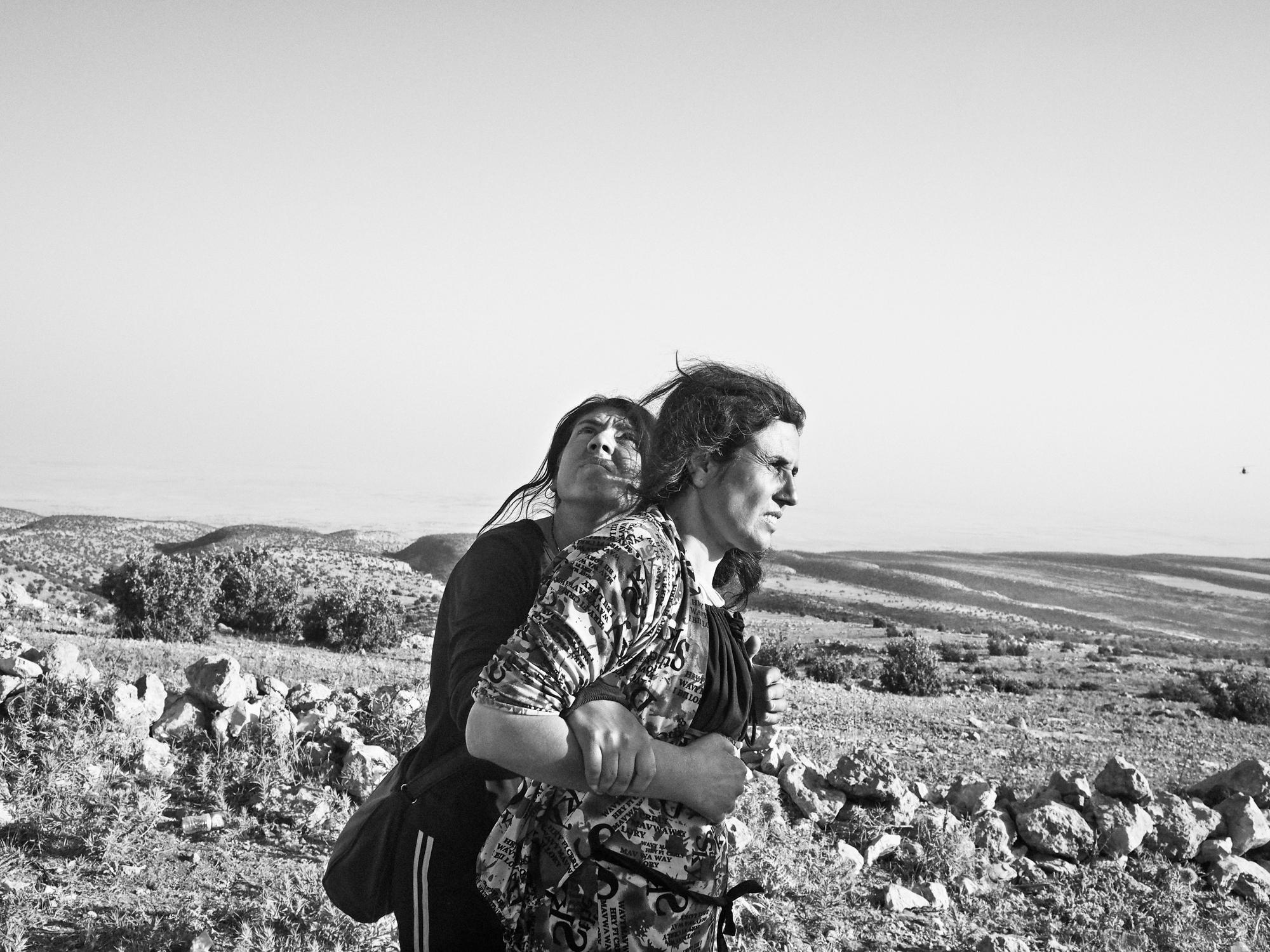 IRAQ. Sinjar Mountains. August 12, 2014. Yazidi women stranded in the Singar Mountains wait for the arrival of a rescue helicopter.