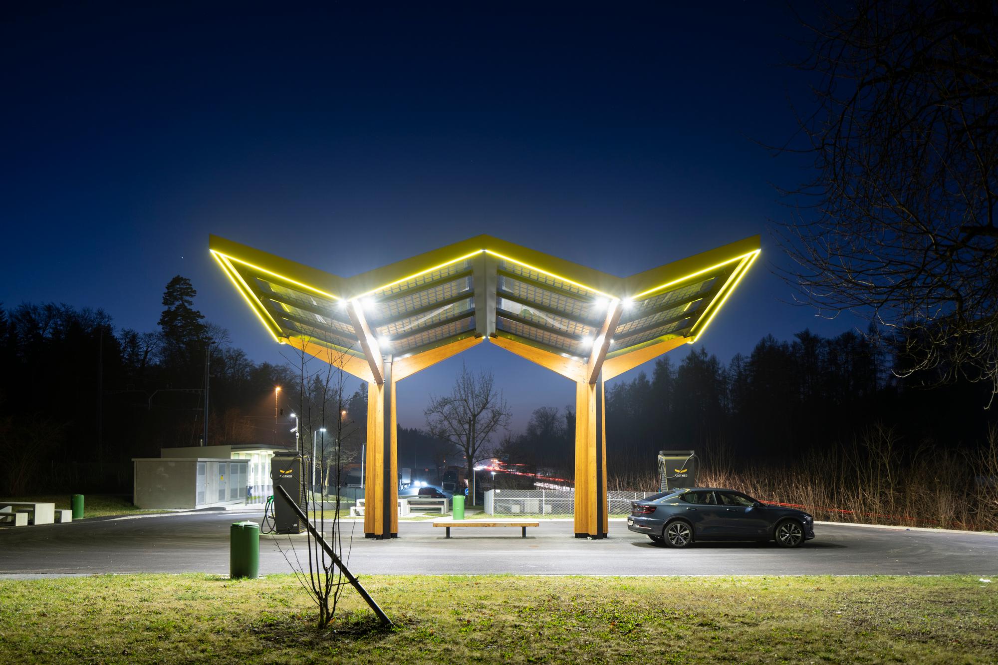 Fastned Schnellladestation mit Solardach auf dem Rastplatz auf der A1 bei Lenzburg, fotografiert in der Nacht am Dienstag, 25. Januar 2022. Die Schnellladestation kennzeichnet sich durch das gelbe Fastned-Dach mit Solarmodulen und bietet eine Schnellladung von 300 kW fuer bis zu vier Fahrzeuge gleichzeitig. Damit werden in 15 Minuten bis zu 300 km Reichweite pro Fahrzeug erreicht. Dies ist bis zu 100-mal schneller als das Aufladen zu Hause. (KEYSTONE/Gaetan Bally)