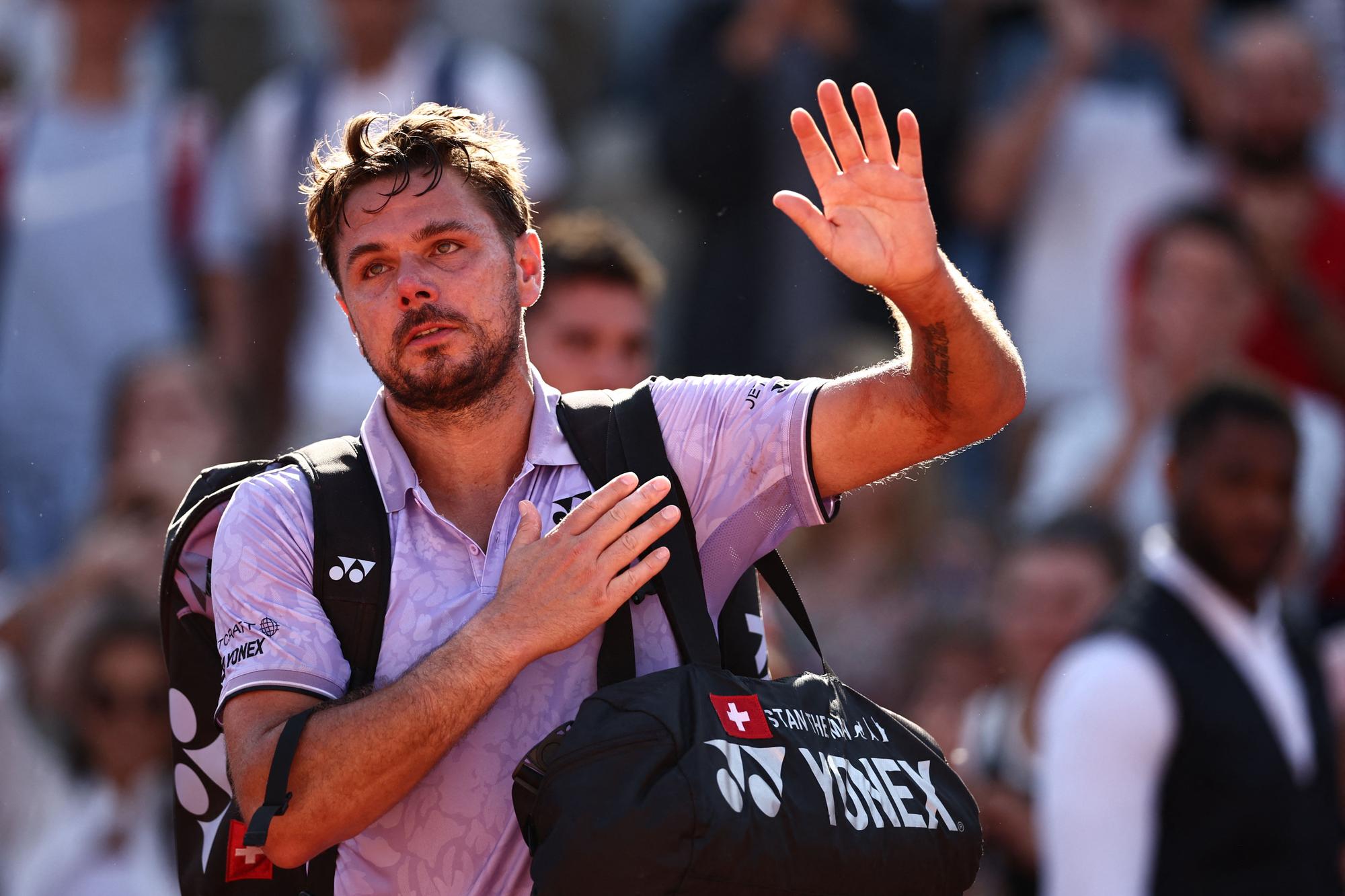 Switzerland's Stan Wawrinka waves as he leaves after being defeated by Australia's Thanasi Kokkinakis during their men's singles match on day four of the Roland-Garros Open tennis tournament at the Court Simonne-Mathieu in Paris on May 31, 2023. (Photo by Anne-Christine POUJOULAT / AFP)