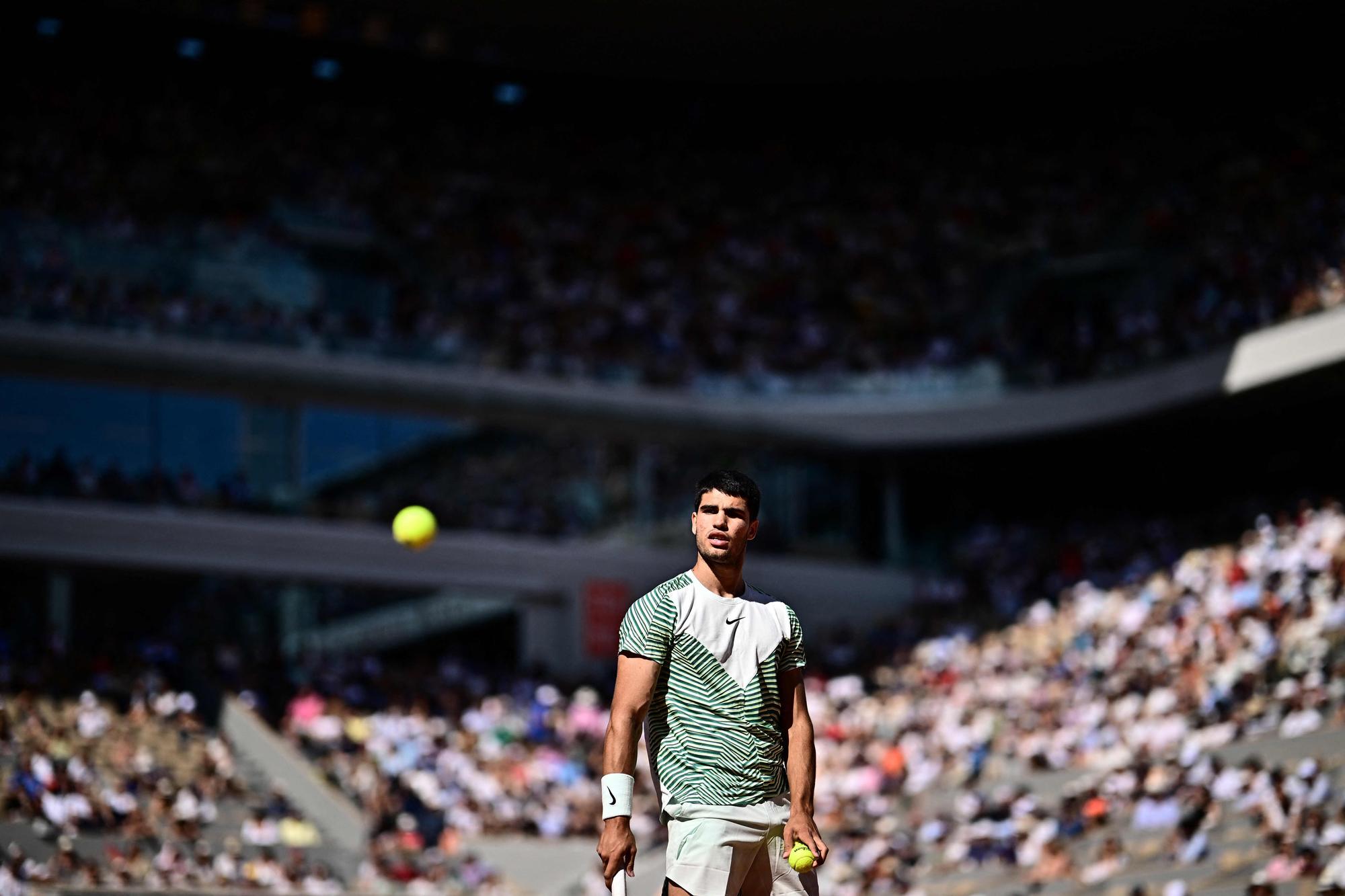 Spain's Carlos Alcaraz Garfia eyes the ball as he plays against Italy's Lorenzo Musetti during their men's singles match on day eight of the Roland-Garros Open tennis tournament at the Court Philippe-Chatrier in Paris on June 4, 2023. (Photo by JULIEN DE ROSA / AFP)