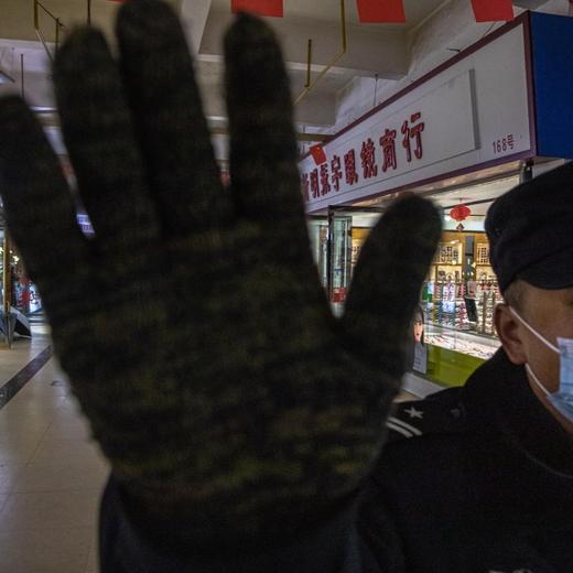 Un gardien repousse un photographe dans le marché couvert de Wuhan le 29 décembre.