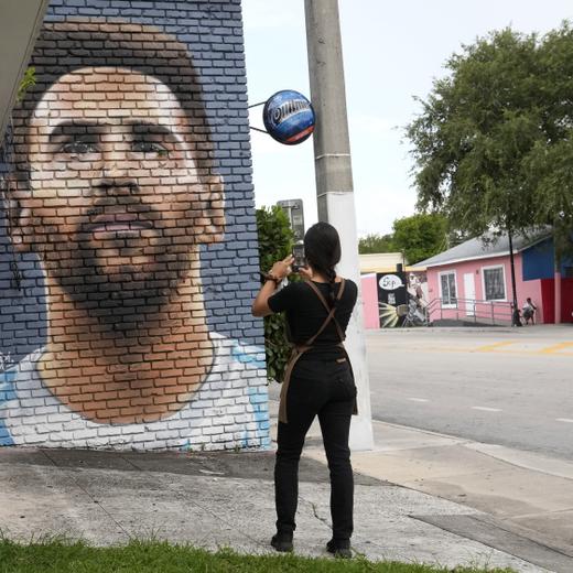 Jessica Ospina takes a photograph of a mural of Lionel Messi outside of the Fiorito restaurant, Wednesday, June 7, 2023, in Miami. The Argentine soccer star announced Wednesday he is joining the Inter Miami Major League Soccer team. (AP Photo/Lynne Sladky)