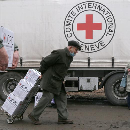 Local residents gather near a cargo trailer loaded with boxes containing food and personal hygiene products during the distribution of humanitarian aid from the International Committee of the Red Cross in the rebel-controlled city of Donetsk, Ukraine, March 17, 2021. REUTERS/Alexander Ermochenko