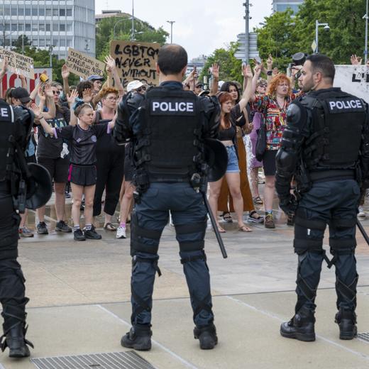 People protest in front of Swiss riot police at a public lecture by Women's rights activist "Posie Parker" (real name Kellie-Jay Keen), during a Let Women Speak rally on the place des Nations in front of the European headquarters of the United Nations, in Geneva, Switzerland, Sunday, June 11, 2023. KEYSTONE/Martial Trezzini)