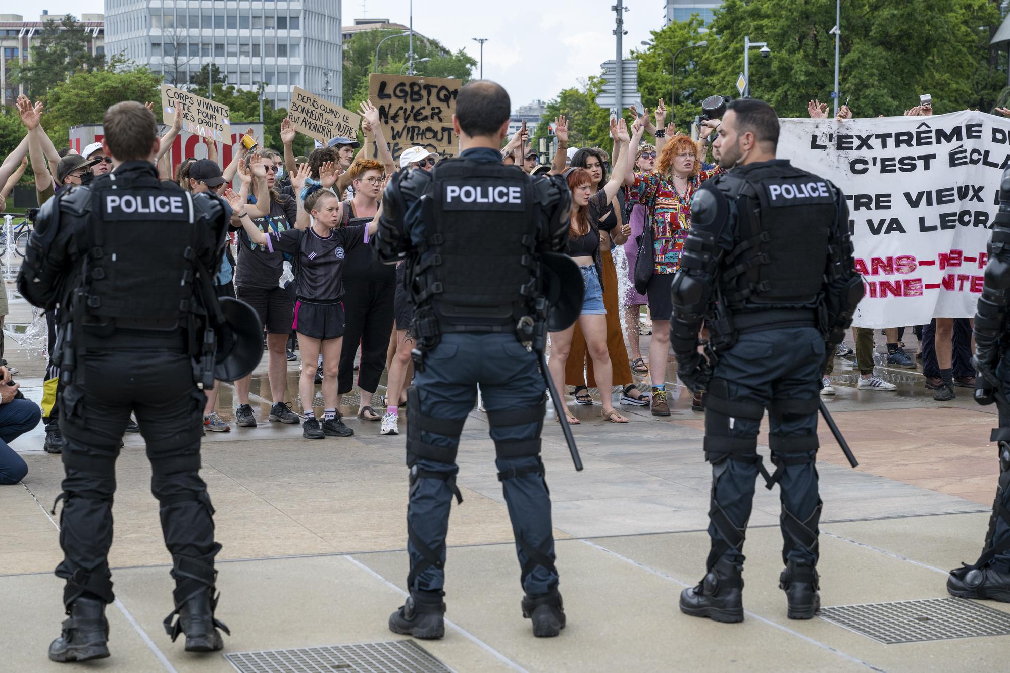People protest in front of Swiss riot police at a public lecture by Women's rights activist "Posie Parker" (real name Kellie-Jay Keen), during a Let Women Speak rally on the place des Nations in front of the European headquarters of the United Nations, in Geneva, Switzerland, Sunday, June 11, 2023. KEYSTONE/Martial Trezzini)