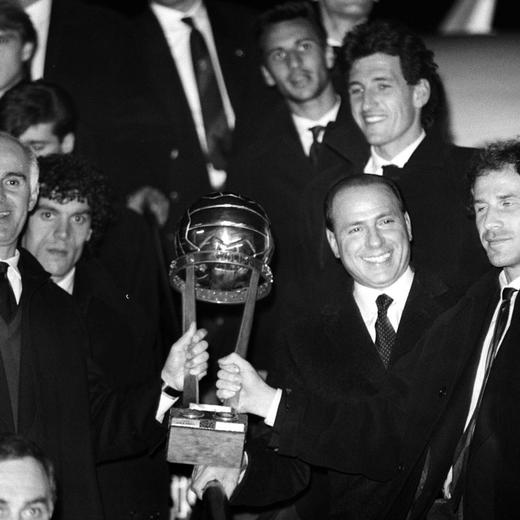 FILE - AC Milan former coach Arrigo Sacchi, left, AC Milan president Silvio Berlusconi, second from right, and Franco Baresi, right, show the Intercontinental Cup as they arrive at the Milan Linate airport on Dec. 1990. From his grand entrance by helicopter after buying AC Milan to empowering Monza up to Serie A for the first time in its history, Silvio Berlusconi dominated Italian soccer for decades just like he commanded the show in Italian politics. Berlusconi, a former three-time Italian premier, died Monday, according to his television network. He was 86. (AP Photo/Luca Bruno, File)