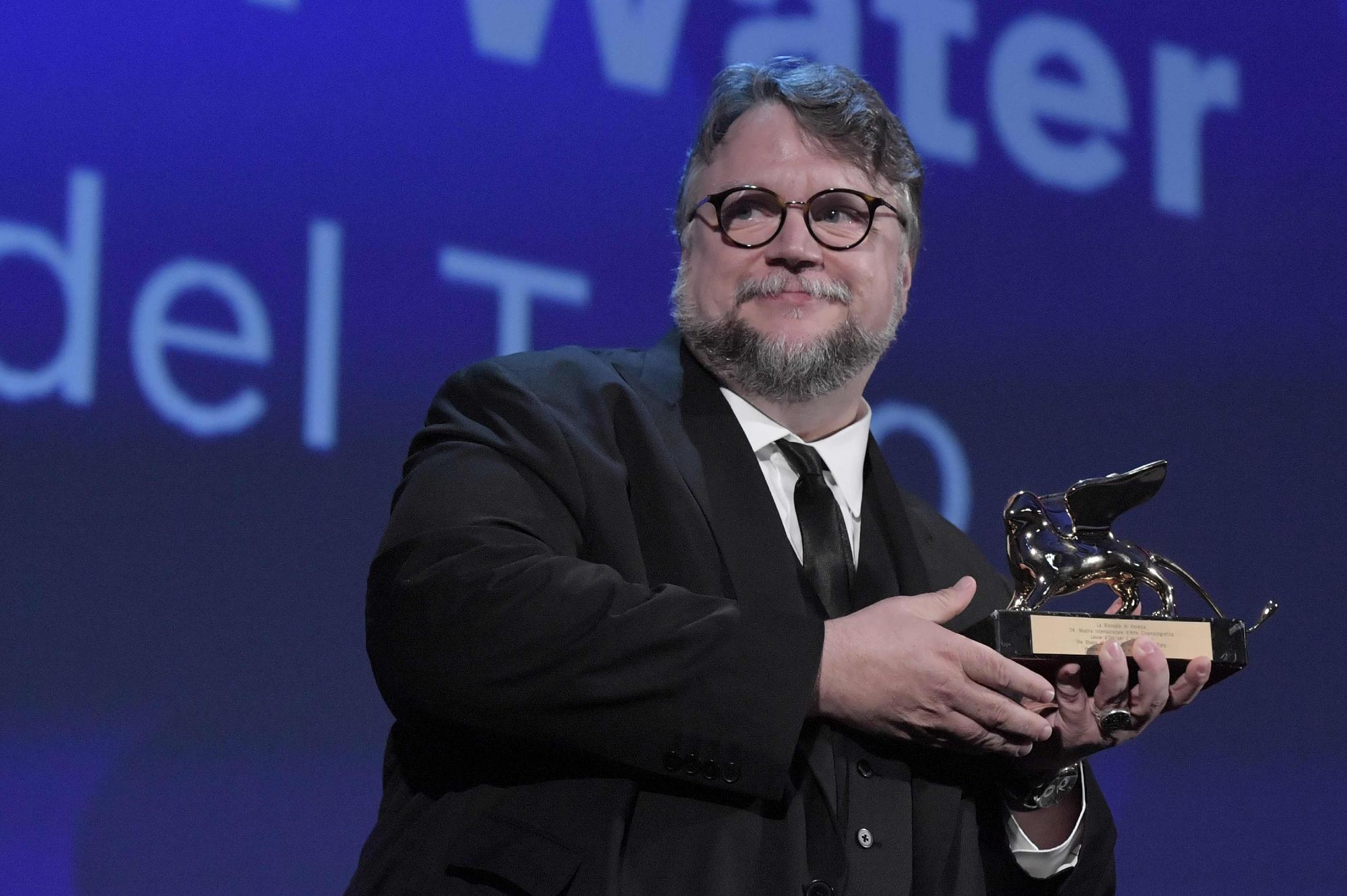 (FILES) This file photo taken on September 9, 2017 shows Mexican director Guillermo Del Toro receiving the Golden Lion for Best Film with the movie "The Shape of Water" during the award ceremony of the 74th Venice Film Festival at Venice Lido.  Long before he was the celebrated director of fantasy romance "The Shape of Water," this year's top Oscar contender with 13 nominations, Guillermo del Toro was fascinated with monsters and the movies. Teachers in his hometown, Guadalajara, Mexico, remember him coming to class with giant cockroaches, and friends recall helping him shoot his first movie at their school -- an eight-millimeter short film featuring a gelatinous monster. / AFP PHOTO /
