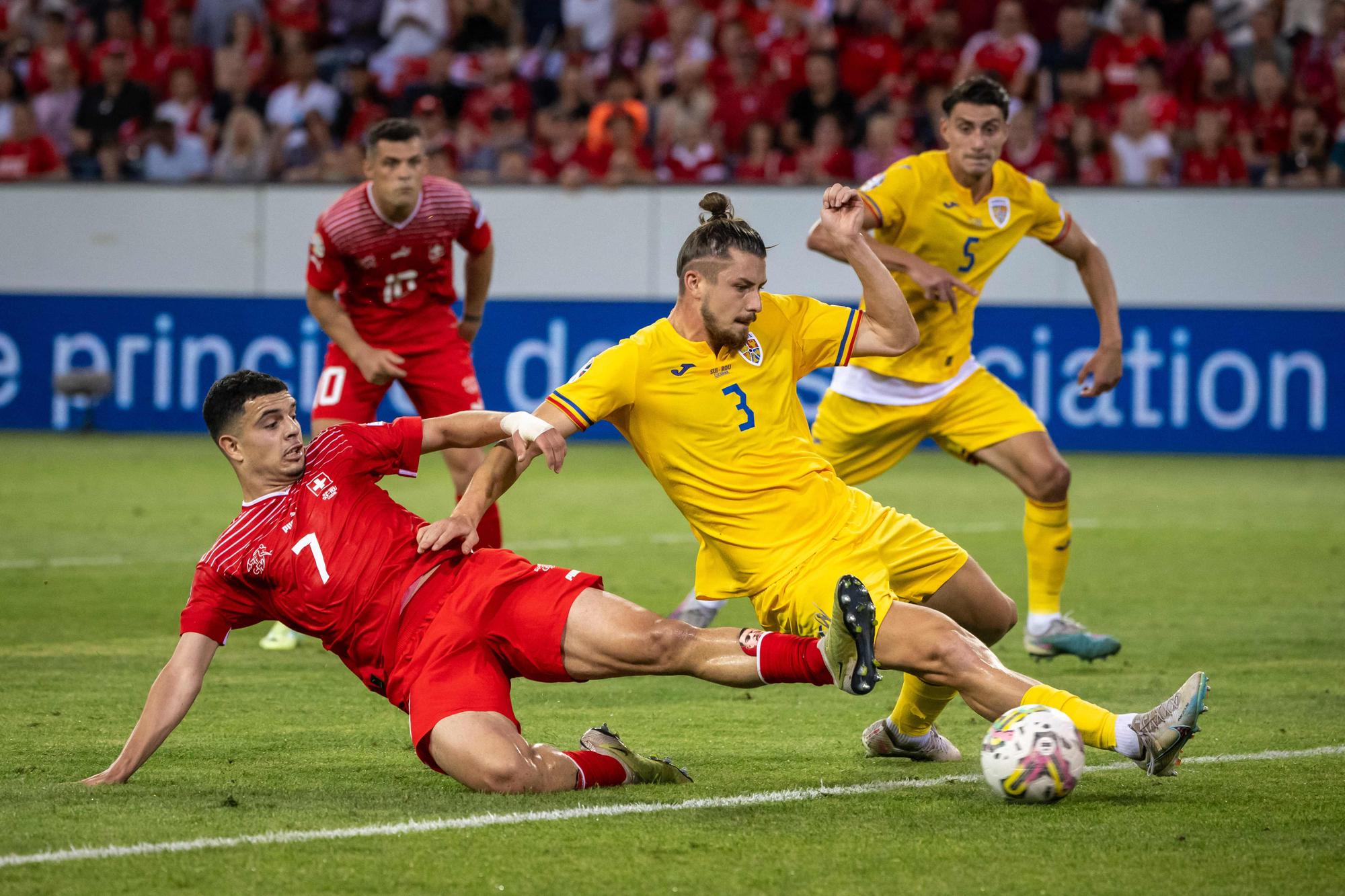 Switzerland's forward Zeki Amdouni (L) fights for the ball with Romania's defender Radu Dragusin during the UEFA Euro 2024 group I qualifying round football match between Switzerland and Romania in Lucerne, on June 19, 2023. (Photo by Fabrice COFFRINI / AFP)