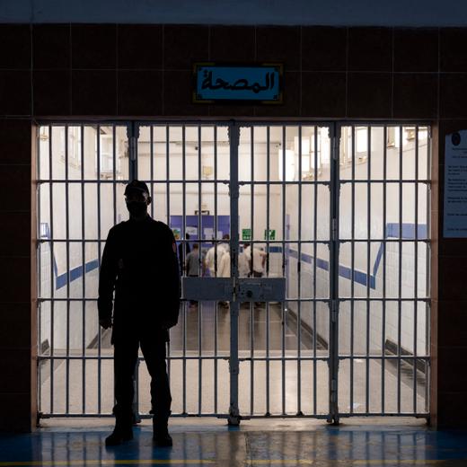 A guard stands in front of one of the gates inside the prison of Kenitra, in the coastal city of the same name, near the Moroccan capital Rabat, on August 31, 2021. After passing through the North African kingdom's Moussalaha ("Reconciliation") programme, some prisoners are hoping for a reprieve. The programme, launched in 2015 and led by Morocco's DGAPR prison service with several partner organisations, aims to help terror detainees who are willing to question their beliefs. (Photo by FADEL SENNA / AFP)