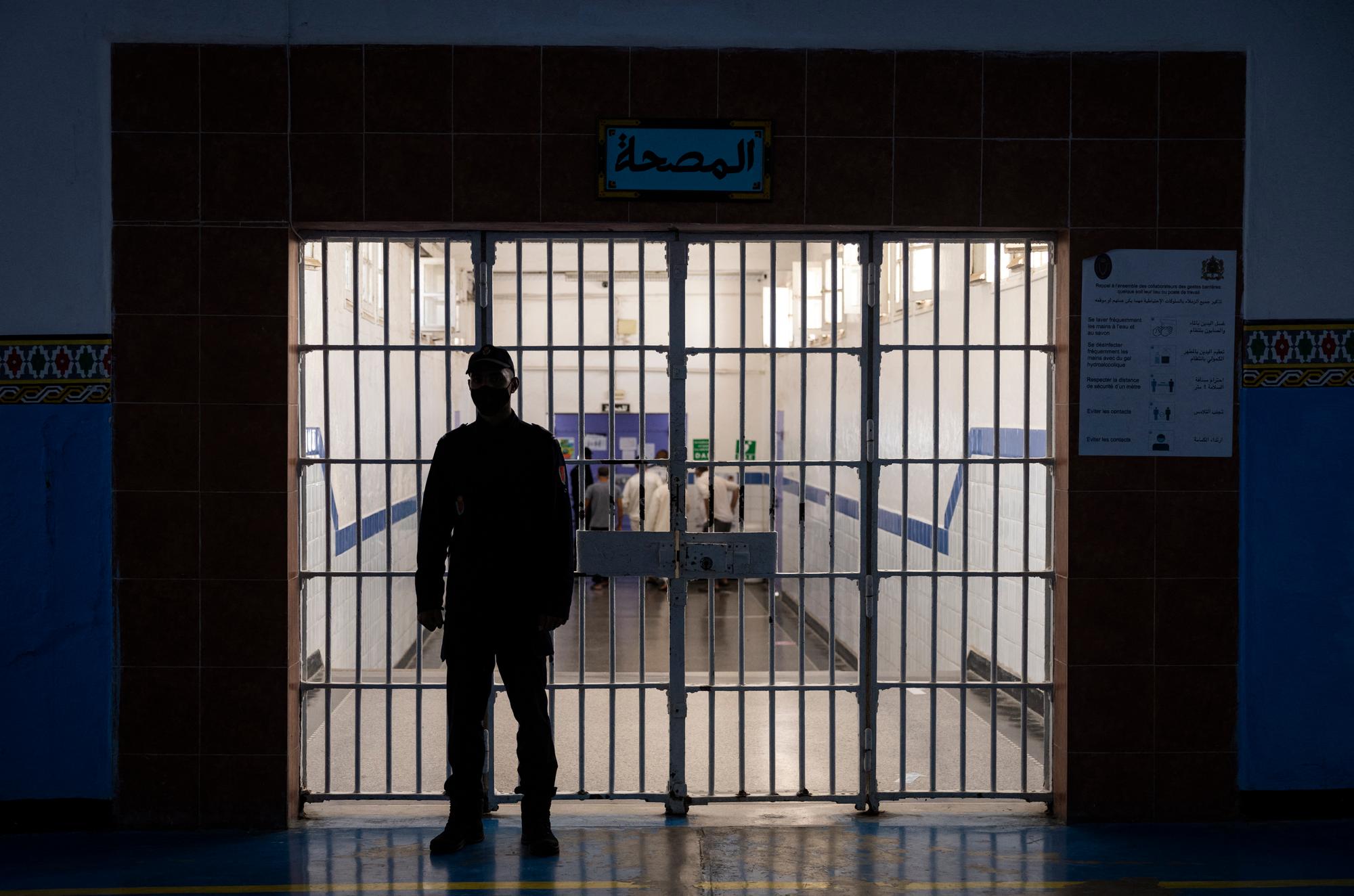 A guard stands in front of one of the gates inside the prison of Kenitra, in the coastal city of the same name, near the Moroccan capital Rabat, on August 31, 2021. After passing through the North African kingdom's Moussalaha ("Reconciliation") programme, some prisoners are hoping for a reprieve. The programme, launched in 2015 and led by Morocco's DGAPR prison service with several partner organisations, aims to help terror detainees who are willing to question their beliefs. (Photo by FADEL SENNA / AFP)