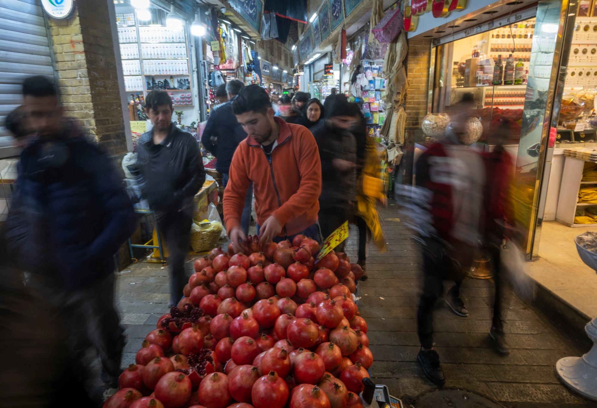 An Iranian vendor adjusts pomegranates, which are a main symbol of Yalda night, on a cart in a traditional bazaar (Market) in northern Tehran, December 20, 2022. In Iran, Yalda Night, also known as Chelle Night, is celebrated on December 21st on the last night of fall. However, due to recent unrest in the country, Yalda night may not be celebrated as in previous years. (Photo by Morteza Nikoubazl/NurPhoto) (Photo by Morteza Nikoubazl / NurPhoto / NurPhoto via AFP)