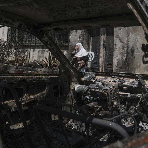 A Palestinian woman sits outside her torched home, days after it was set on fire by Jewish settlers, in the West Bank town of Turmus Ayya, Saturday, June 24, 2023. Israeli settlers entered the town, setting fire to Palestinian cars and homes after four Israelis were killed by Palestinian gunmen in the northern West Bank on Tuesday. (AP Photo/Mahmoud Illean)