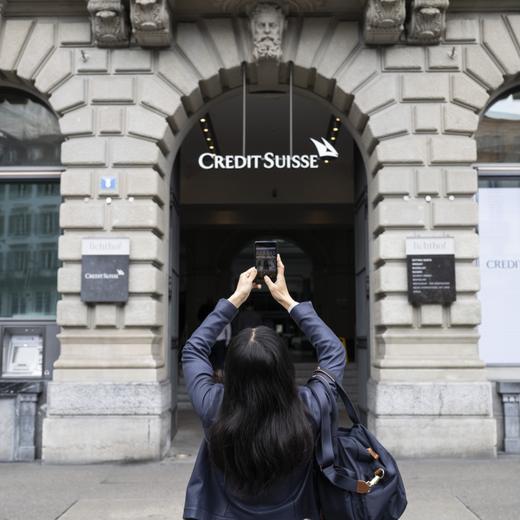 A woman takes photos of a logo of the Swiss bank Credit Suisse in Zurich, Switzerland, 20 March 2023. The bank UBS takes over Credit Suisse for 2 billion US dollars. Shares of Credit Suisse lost more than one-quarter of their value on 15 March 2023, hitting a record low after its biggest shareholder, the Saudi National Bank, told outlets that it would not inject more money into the ailing Swiss bank. (KEYSTONE/Ennio Leanza)