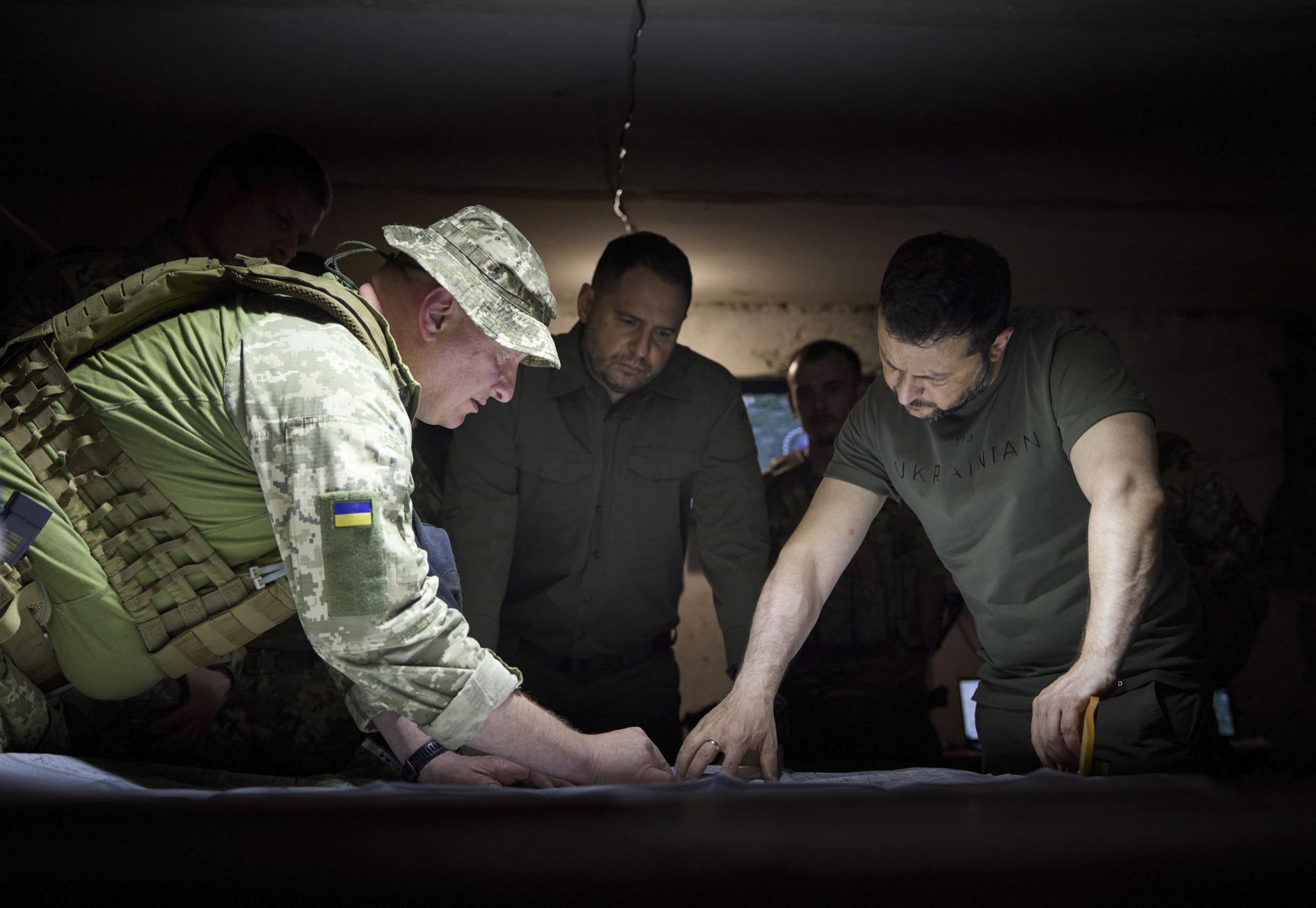 Le président Zelensky (à droite) devant une carte de l'Ukraine, lundi dans la région de Donetsk