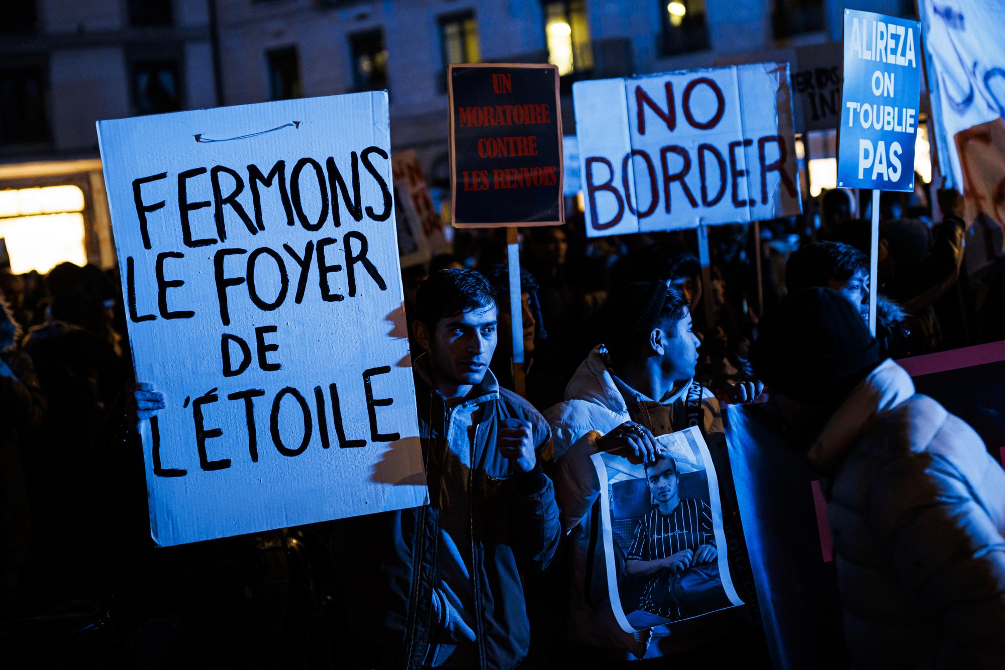 Des personnes manifestent devant l'Hospice General avant un cortege visant a interpeller les autorites cantonales suite au suicide d'Alireza, jeune afghan qui residait au foyer de l?Etoile, ce jeudi 8 decembre 2022 a Geneve. (KEYSTONE/Valentin Flauraud)