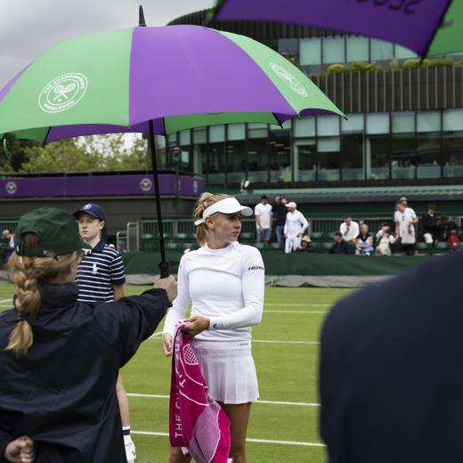 Jil Teichmann of Switzerland waits while the play is suspended due to rain during her first round match against Magda Linette of Poland at the All England Lawn Tennis Championships in Wimbledon, London, Monday, July 3, 2023. (KEYSTONE/Peter Klaunzer)
