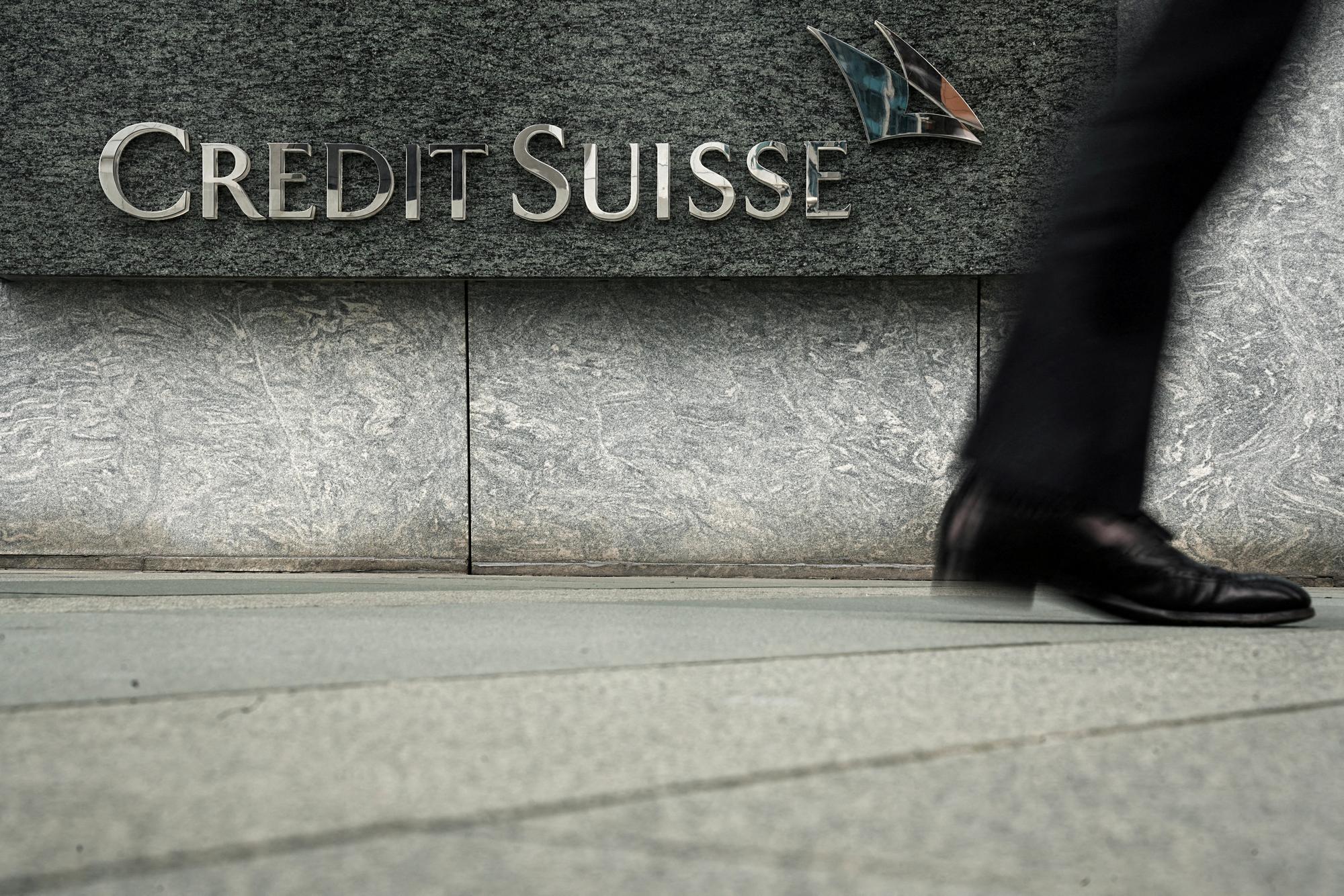 FILE PHOTO: A pedestrian walks past a logo of Credit Suisse outside its office building in Hong Kong, China March 21, 2023. REUTERS/Lam Yik/File Photo/File Photo