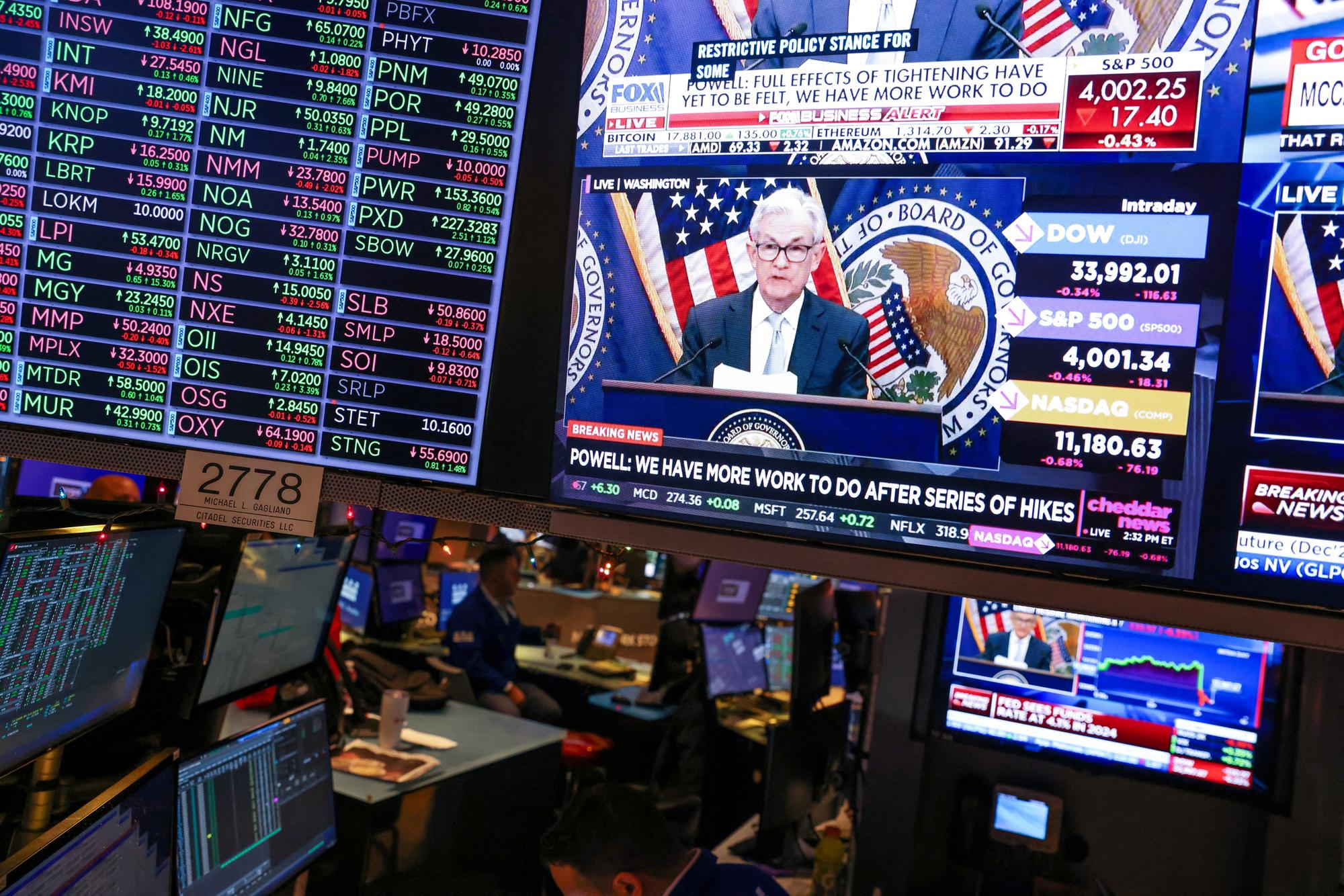 FILE PHOTO: Screens on the trading floor at New York Stock Exchange (NYSE) display the Federal Reserve Chair Jerome Powell, in New York City, U.S., December 14, 2022. REUTERS/Andrew Kelly/File Photo