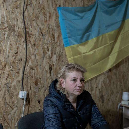 UKRAINE, Orikhiv. 26 janvier 2023 - Svetlana Mandrych, 52 ans, adjointe au maire d'Orikhiv, est assise dans le sous-sol du bâtiment municipal où les employés mènent encore leurs activités.