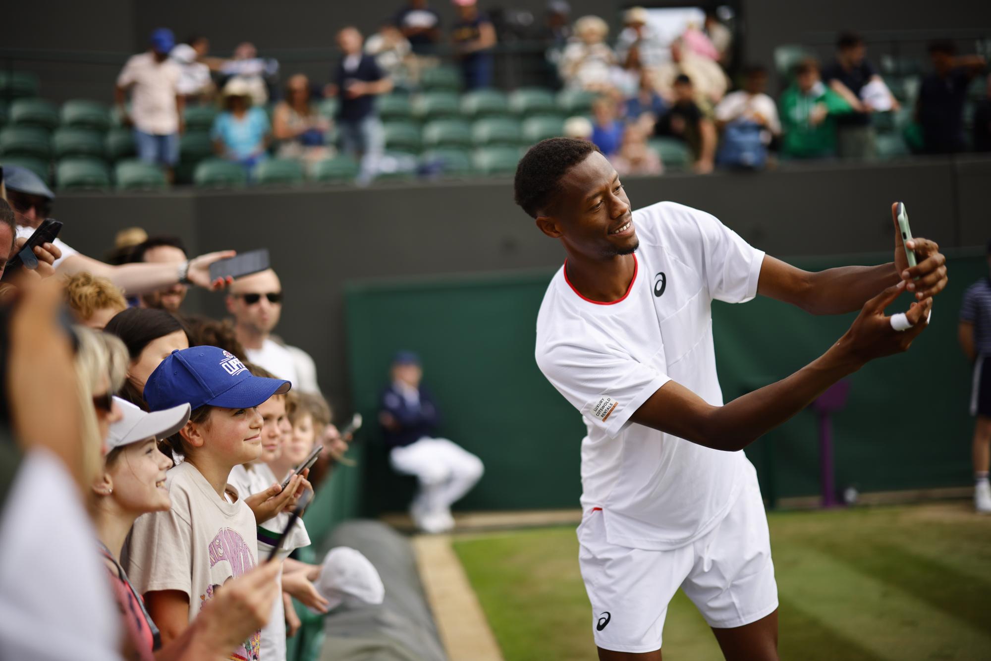 epa10738110 Christopher Eubanks of USA poses for selfies with fans after winning his Men's Singles 4th round match against Stefanos Tstsipas of Greece at the Wimbledon Championships, Wimbledon, Britain, 10 July 2023. EPA/TOLGA AKMEN EDITORIAL USE ONLY