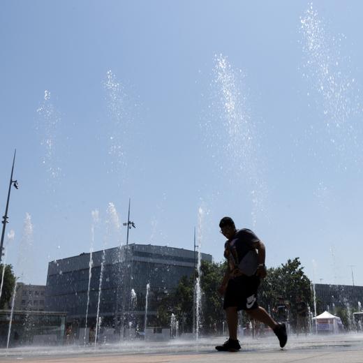 Two men cool off in the fountain on the Place des Nations, in Geneva, Switzerland, Tuesday, July 11, 2023. A heat wave has just entered Geneva and it's day the thermometers will mark temperatures above 38 degrees. (KEYSTONE/Salvatore Di Nolfi)
