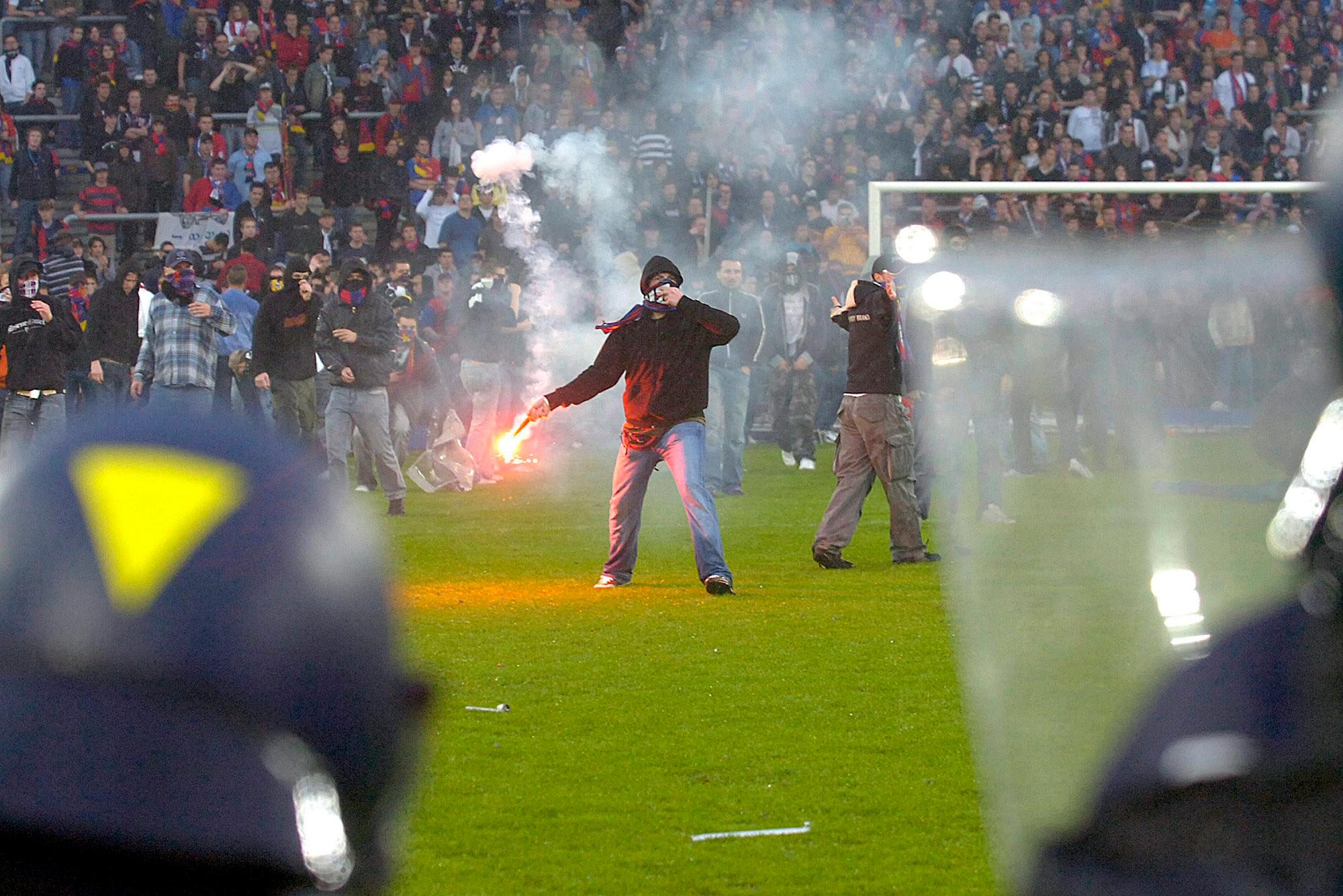 JAHRESRUECKBLICK 2006 - SPORT - SCHWEIZ FUSSBALL FCB FCZ AUSSCHREITUNGEN: Des supporters sont decendu sur le terrain pour provoque la police, a la fin de la rencontre de football de superleage entre la FC Bale et le FC Zurich, ce samedi 13 mai 2006 au Stade Saint-Jacques de Bale - Basel Fans randalieren auf dem Spielfeld nach dem Fussball Meisterschaftsspiel der Super League zwischen dem FC Basel und dem FC Zuerich am Samstag, 13. Mai 2006, in Basel. Der FC Zuerich schlug Basel mit 1:2 Toren und holte sich den Meistertitel. (KEYSTONE/Sandro Campardo)