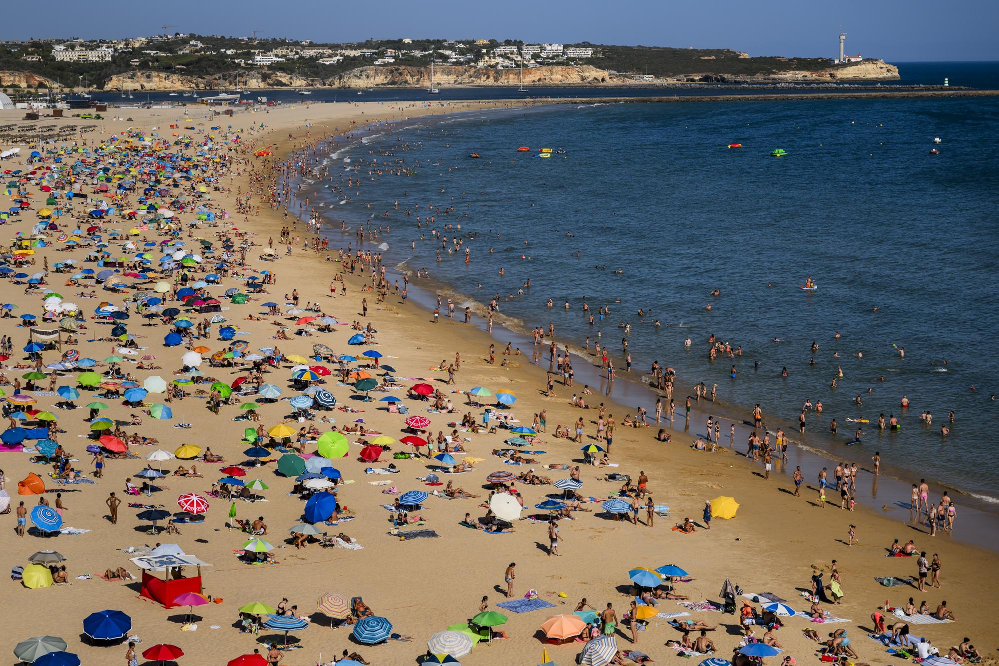 People spend time on the "Praia da Rocha" beach during a hot summer day, in Portimao, Algarve coastline, Portugal, Tuesday, July 11, 2023. Actually a heatwave is sweeping across parts of southern Europe. (KEYSTONE/Jean-Christophe Bott)