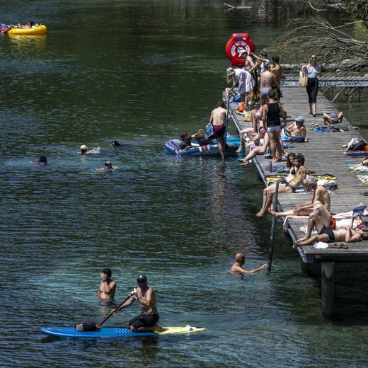 People in inflatable boats float down the Rhone river, as a heat wave reaches the country in Geneva, Switzerland, Saturday, June 18, 2022. People flocked to parks and pools across Western Europe on Saturday for a bit of respite from an early heat wave that saw the mercury rise above 40 Cs (104 F) in France and Spain, and highs of 38 C (100.4 F) in Germany. (KEYSTONE/Martial Trezzini)