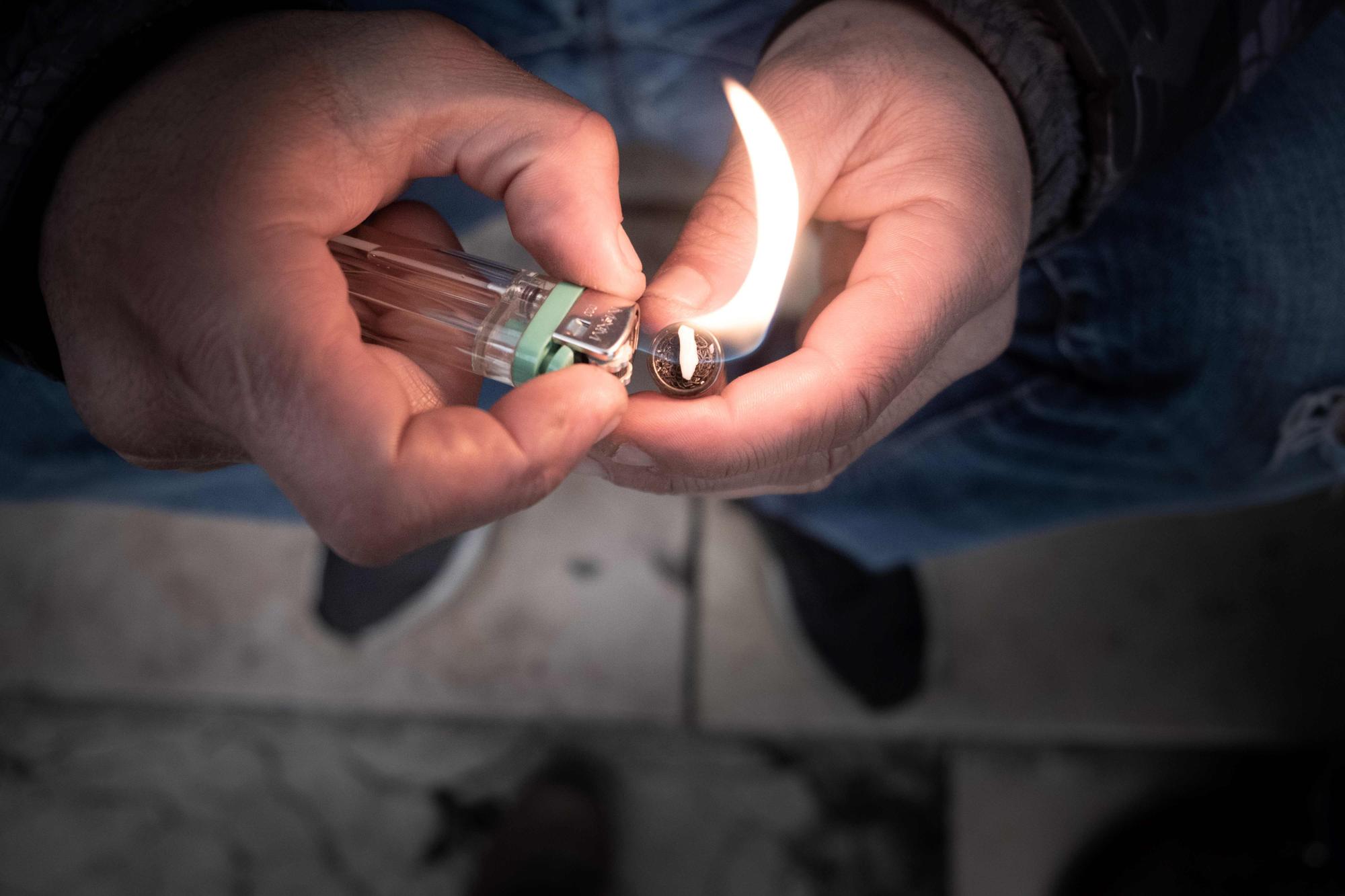 Oussman, a crack addict lights a pipe at Stalingrad Square, nicknamed Stalincrack, on December 2, 2020 in Paris.. ........ . .... - This "drug of the poor" has been wreaking havoc in the north-east of the capital for thirty years. Over the past 18 months, the authorities have been stepping up initiatives to try to curb the use of this smokable derivative of cocaine: reinforced police patrols, arrests of traffickers, accommodation for drug addicts but these efforts have so far been largely unsuccessful. (Photo by JOEL SAGET / AFP) (KEYSTONE/AFP/JOEL SAGET)