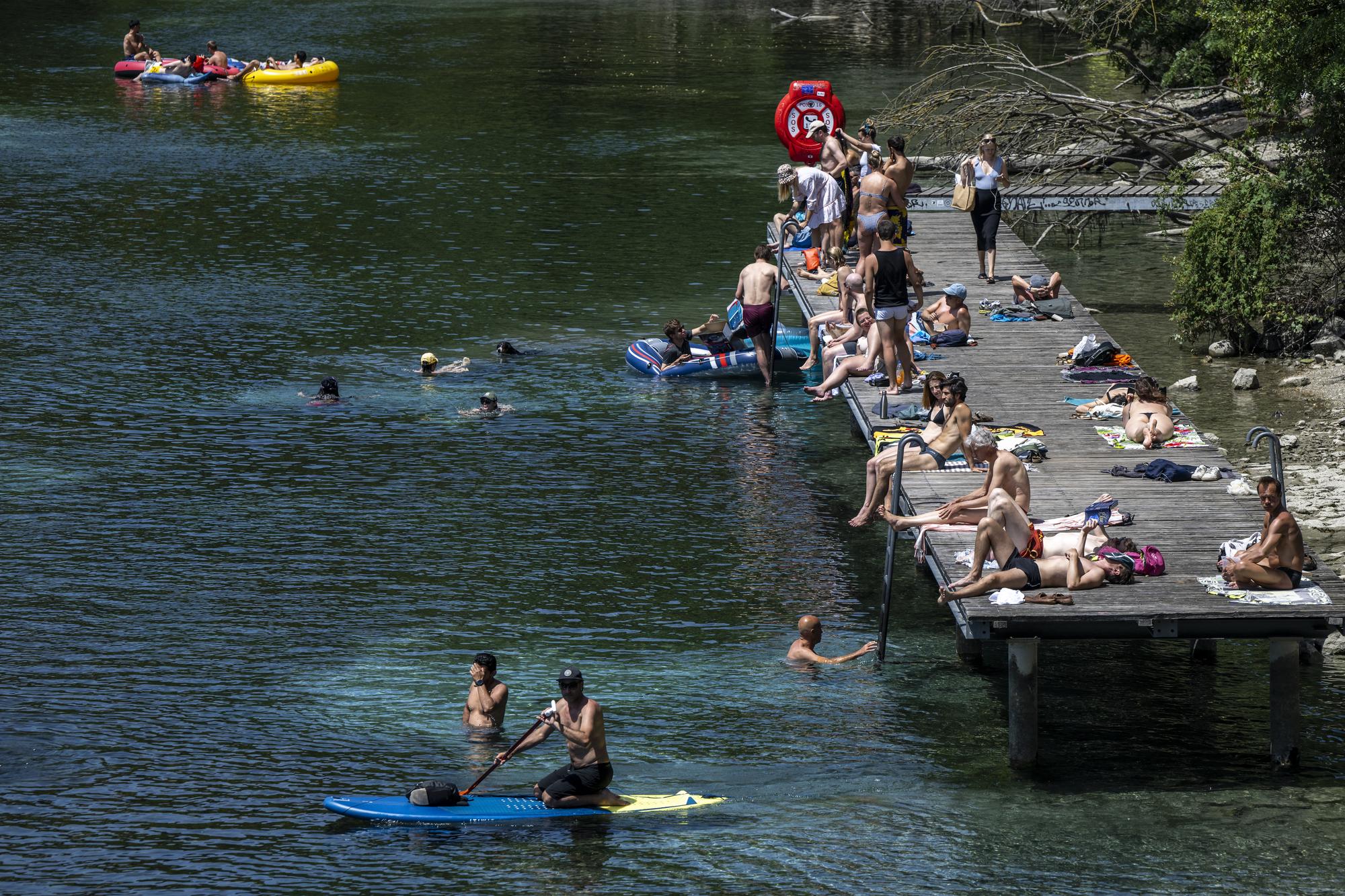 People in inflatable boats float down the Rhone river, as a heat wave reaches the country in Geneva, Switzerland, Saturday, June 18, 2022. People flocked to parks and pools across Western Europe on Saturday for a bit of respite from an early heat wave that saw the mercury rise above 40 Cs (104 F) in France and Spain, and highs of 38 C (100.4 F) in Germany. (KEYSTONE/Martial Trezzini)
