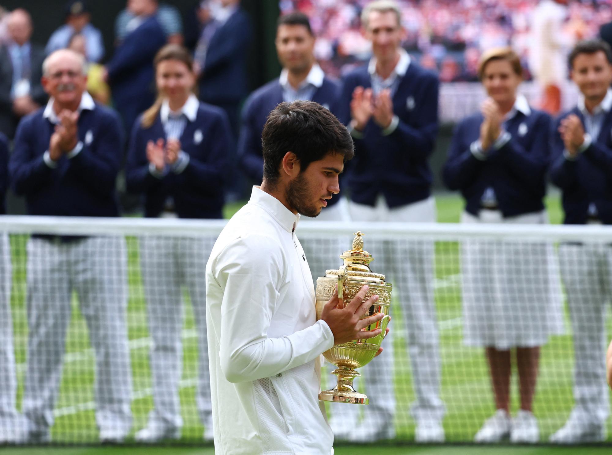 Tennis - Wimbledon - All England Lawn Tennis and Croquet Club, London, Britain - July 16, 2023  Spain's Carlos Alcaraz celebrates with the trophy after winning his final match against Serbia's Novak Djokovic REUTERS/Toby Melville